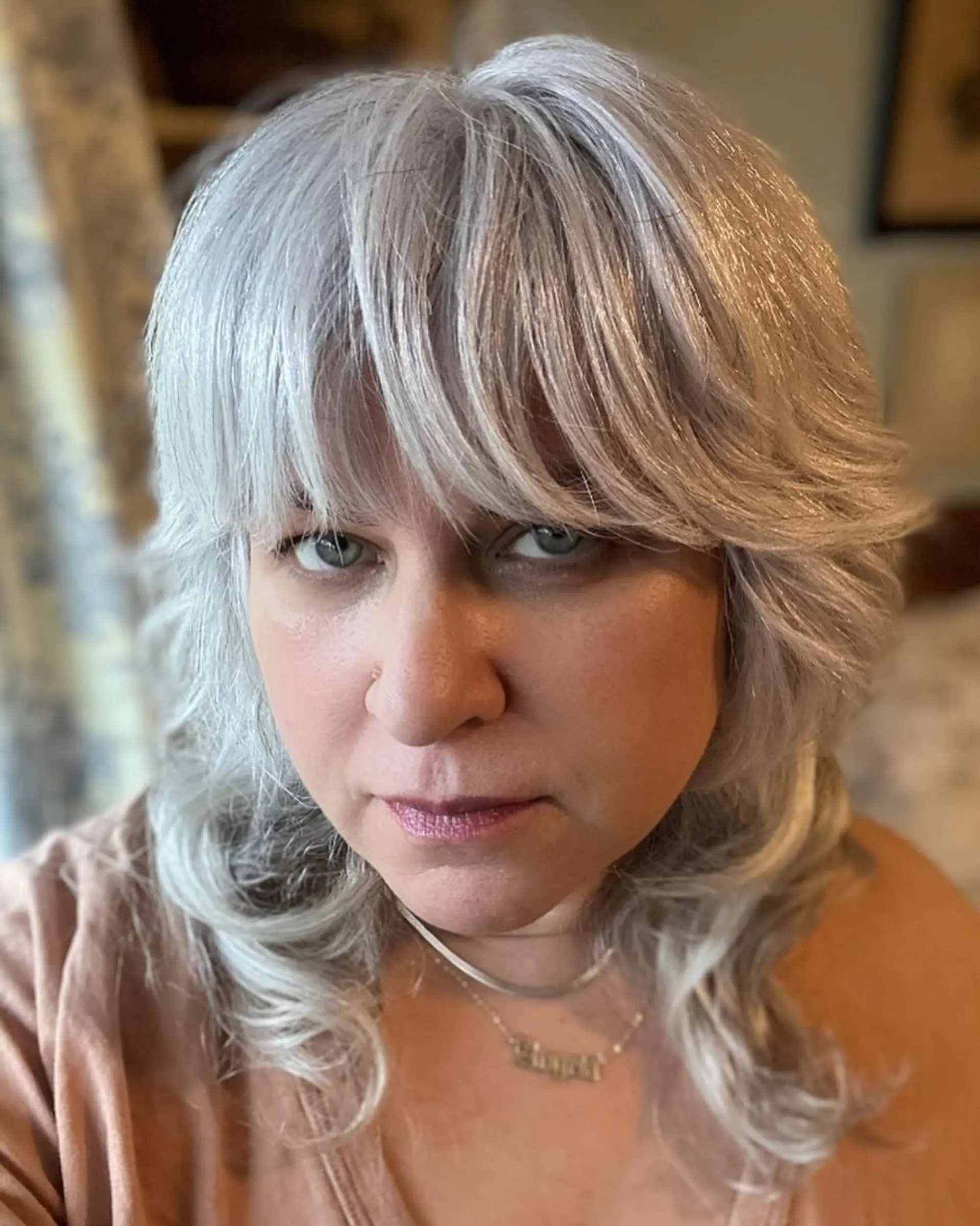 A trendy medium-length shag haircut with layered texture and face-framing bangs. 1