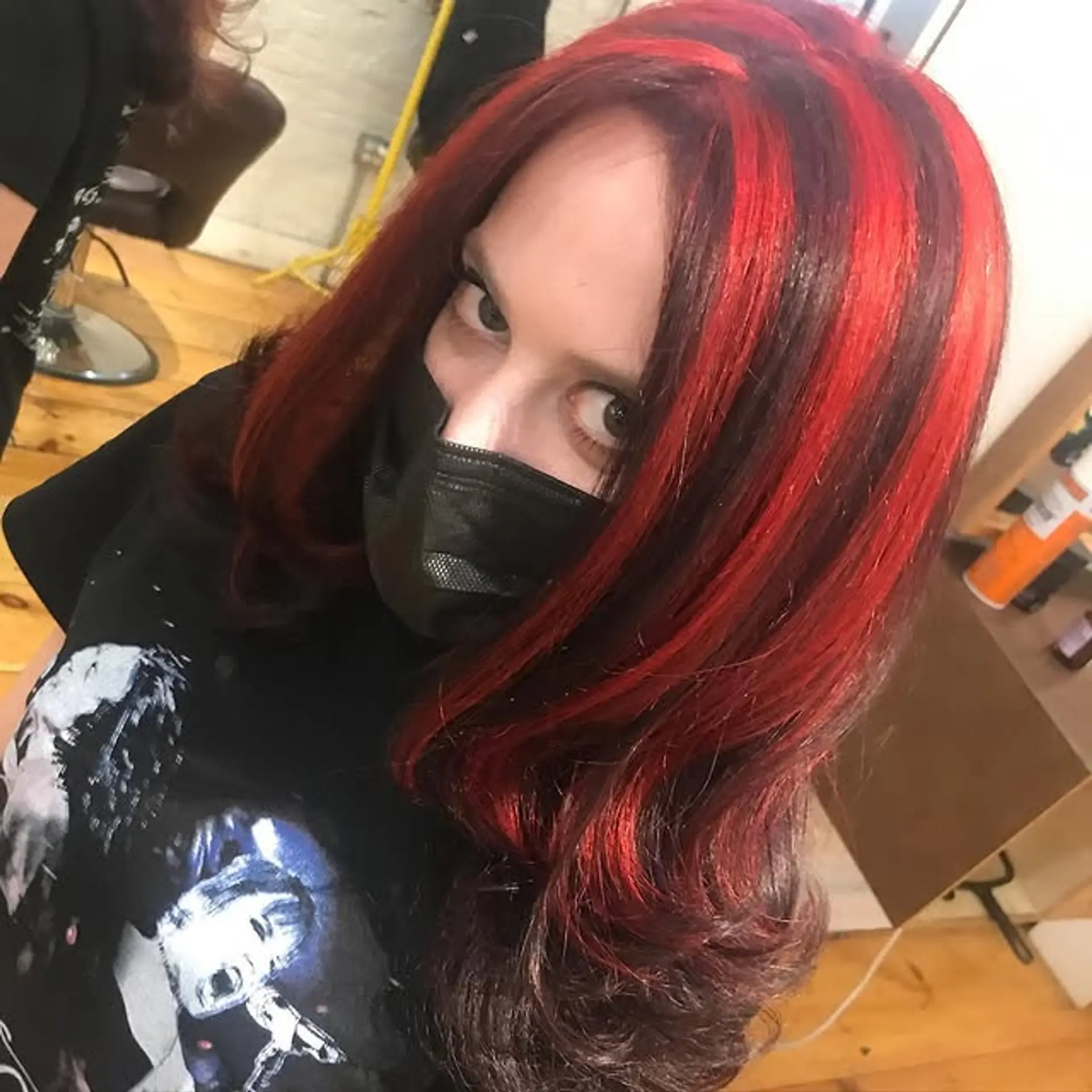 Long, layered wavy hairstyle with bold red streaks on a brunette base. 1