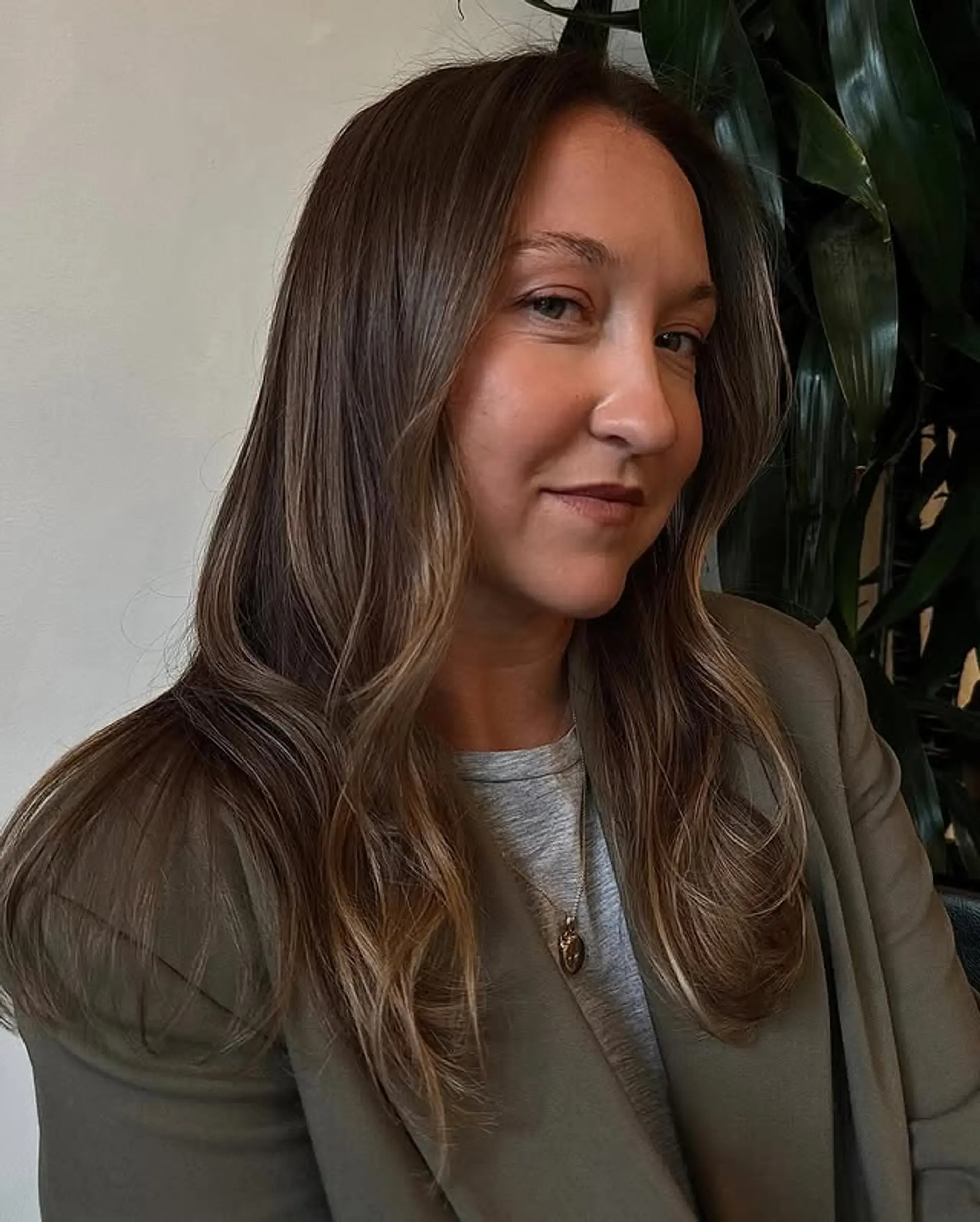 A long, wavy hairstyle with a bronde balayage and face-framing layers. 1