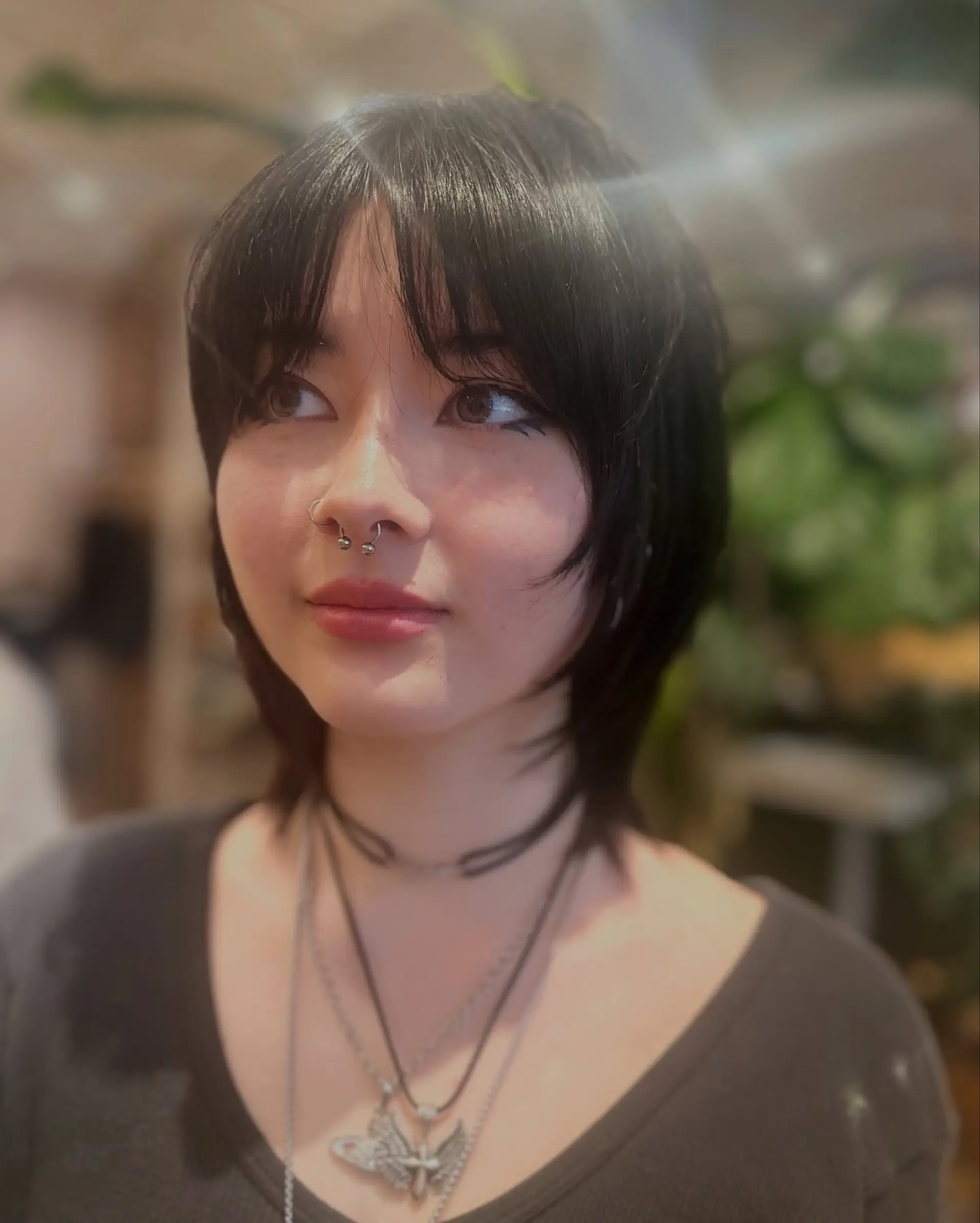 A textured short shag haircut featuring soft front bangs and feathered face-framing layers. 1