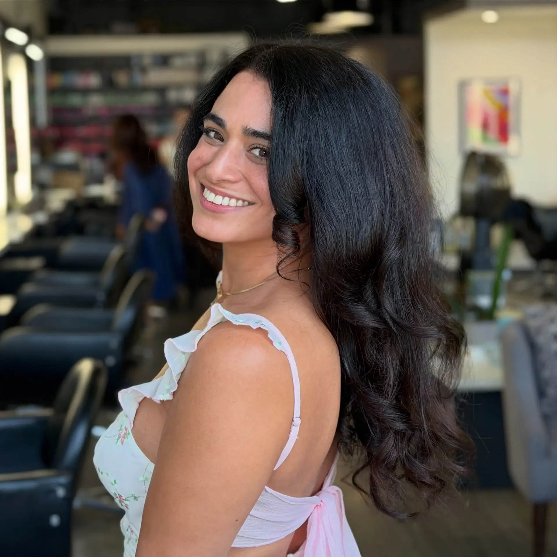 A voluminous, glossy blowout styled with soft, cascading loose waves on long dark hair. 1
