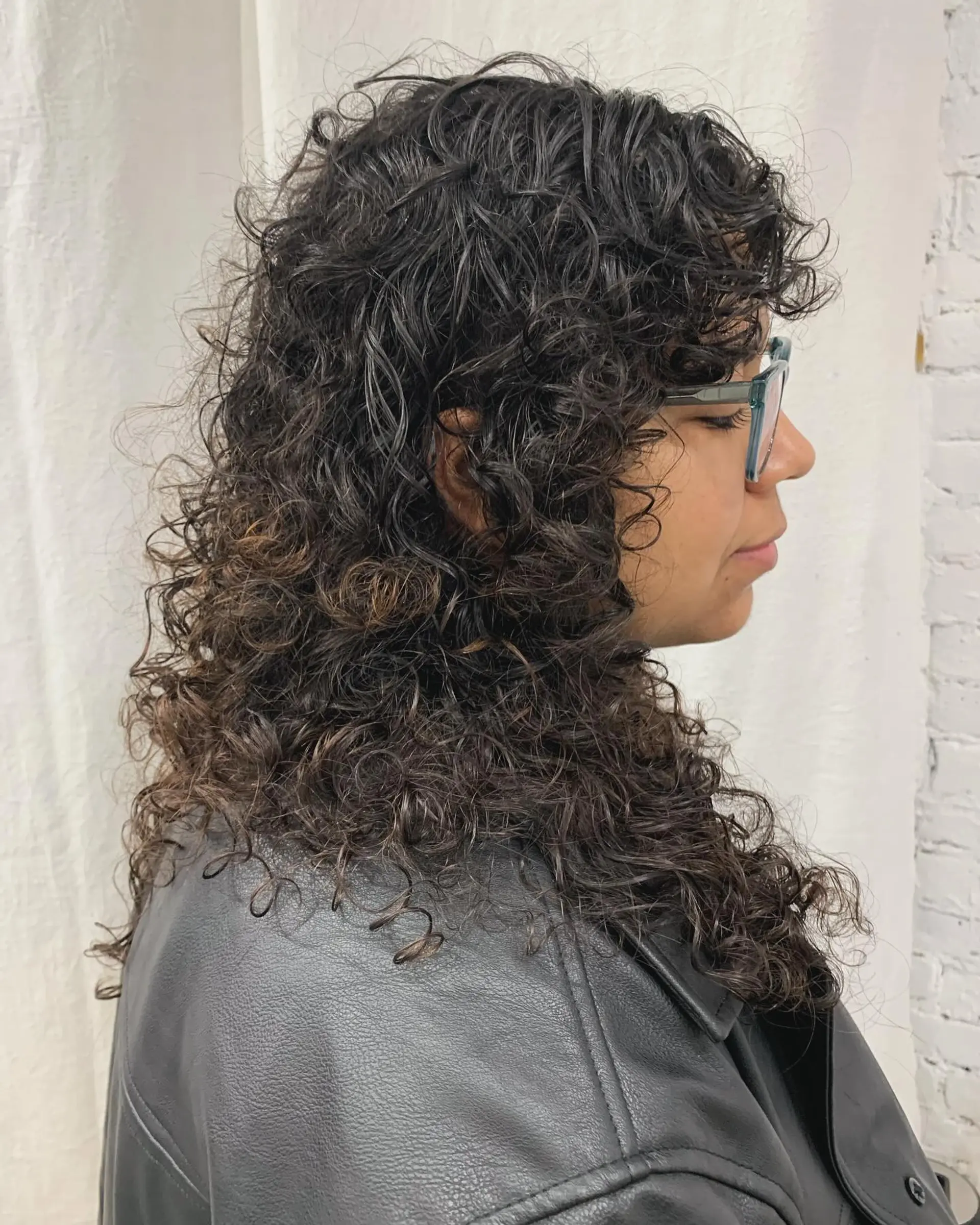 Long, dark brown curly hair with a full fringe and cascading voluminous ringlets. 3