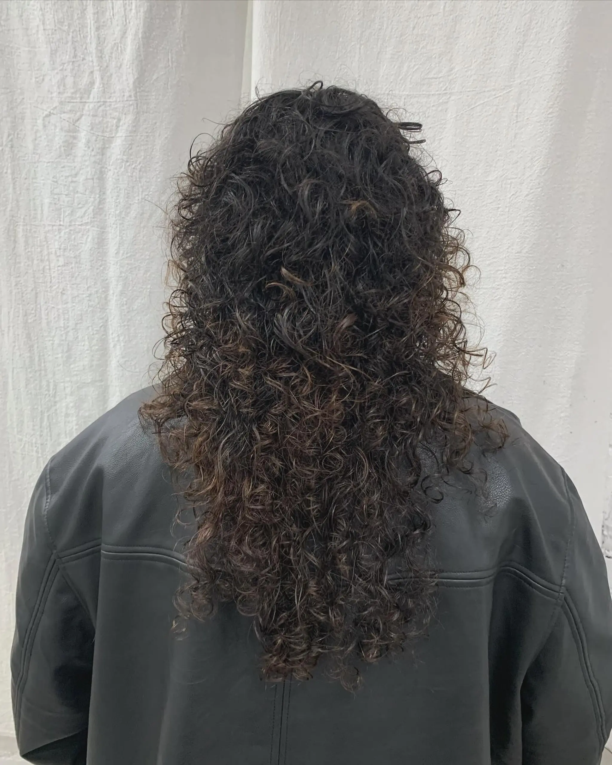 Long, dark brown curly hair with a full fringe and cascading voluminous ringlets. 4