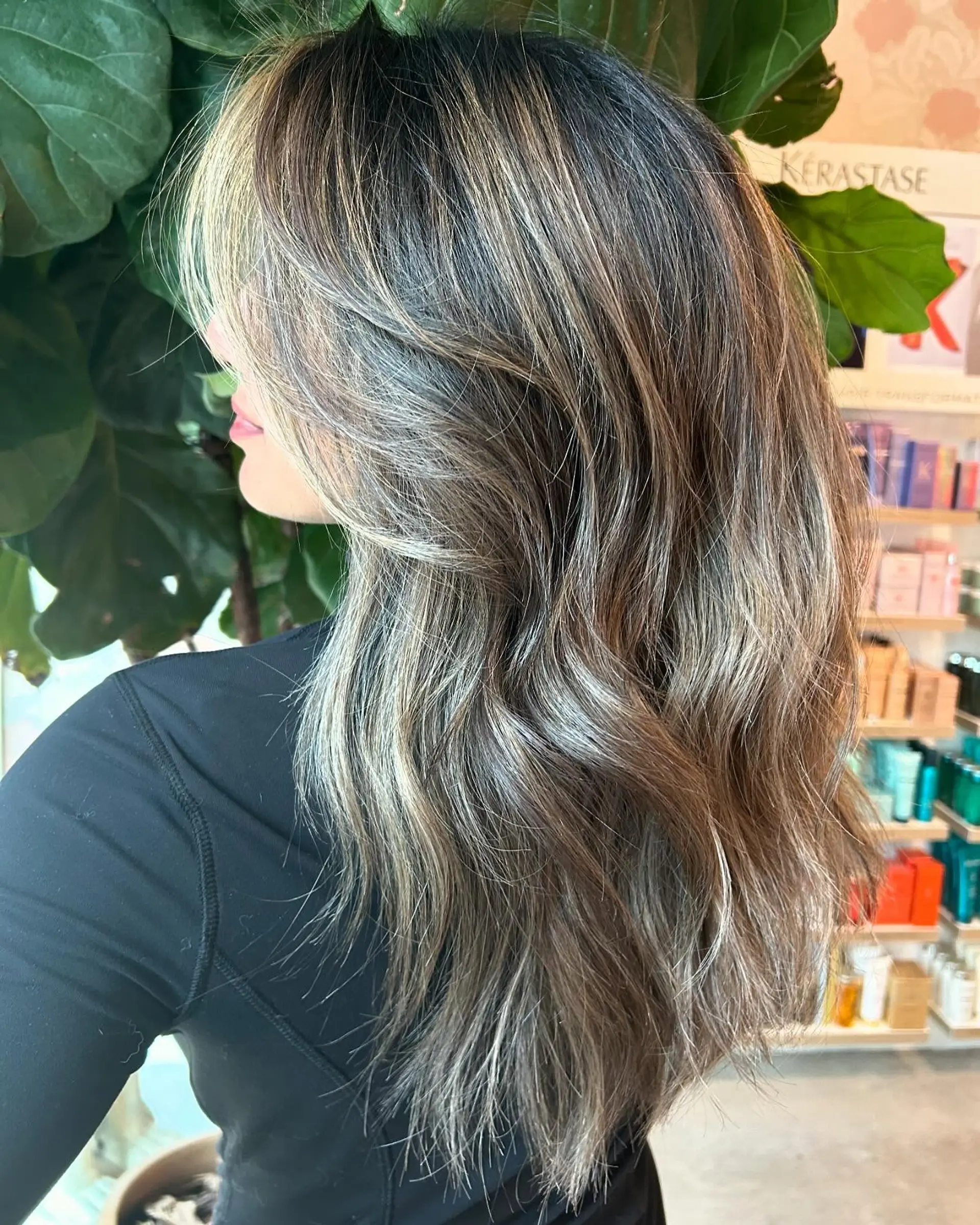 Long mushroom bronde hair with subtle balayage highlights styled in soft, cascading waves and face-framing layers. 1