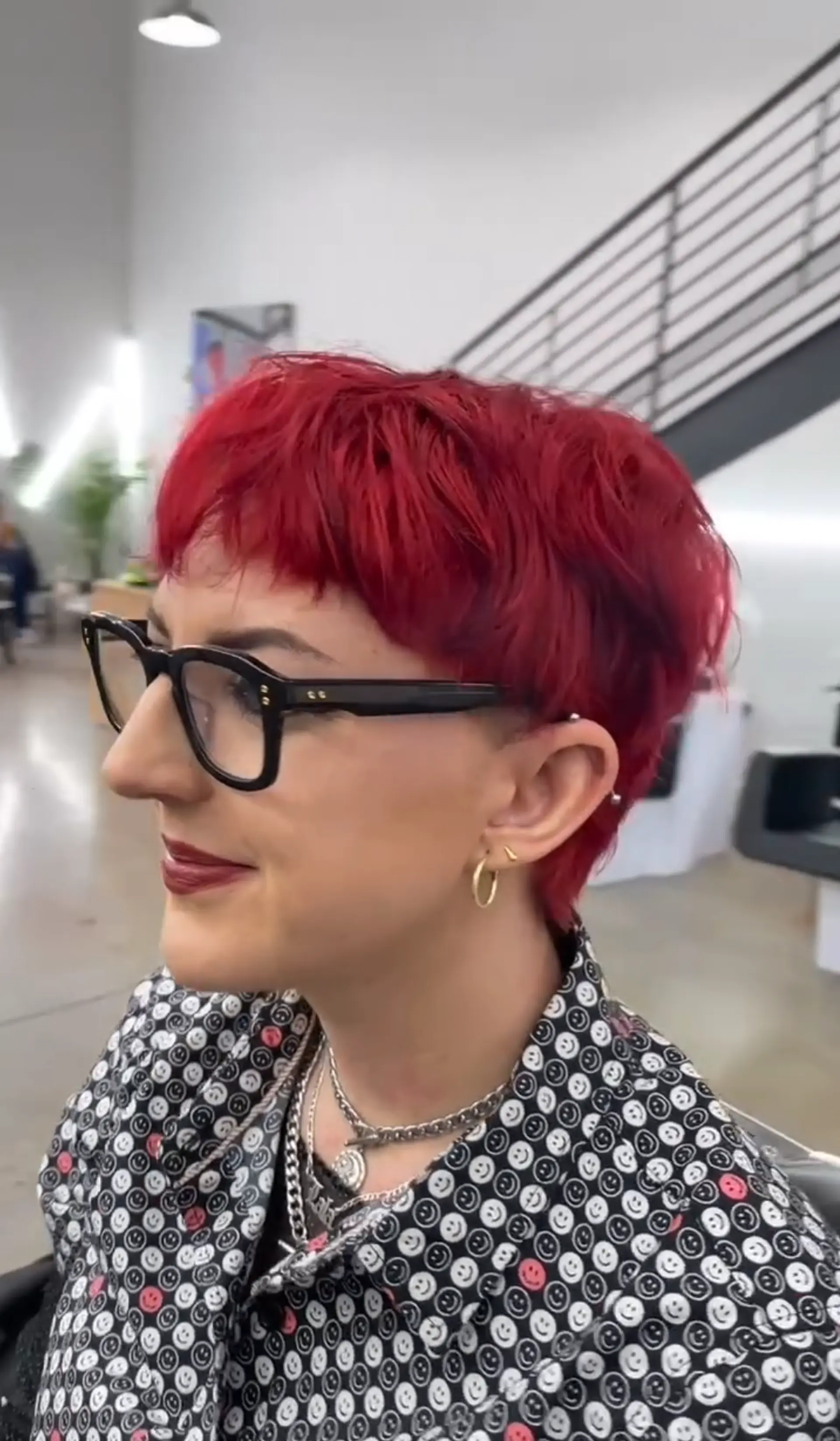 A short, edgy hairstyle with vibrant red hair, featuring a textured fringe and layered cut for added volume and movement. 1