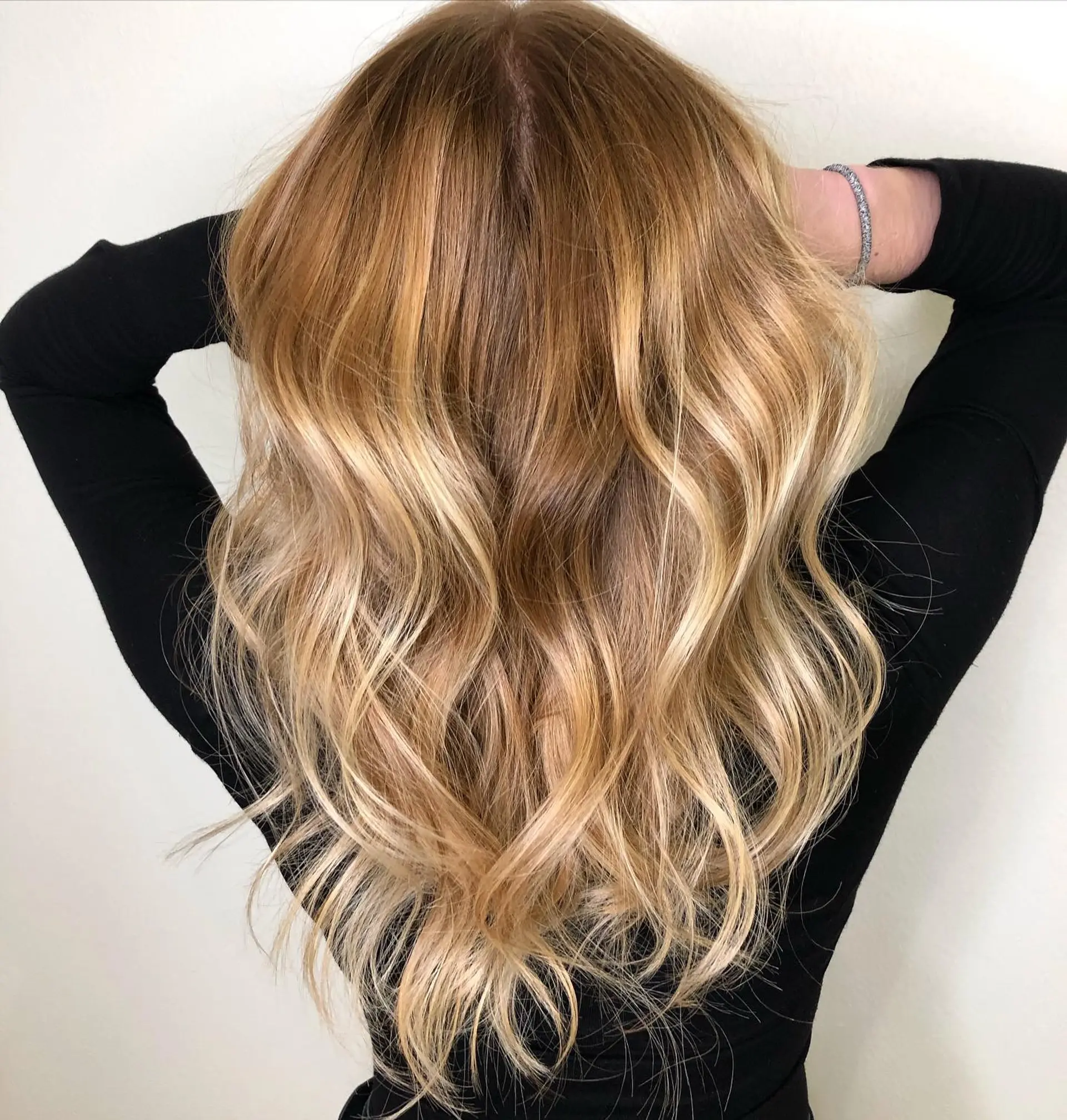 Long hair featuring a warm dimensional blonde balayage styled with soft, effortless waves. 1