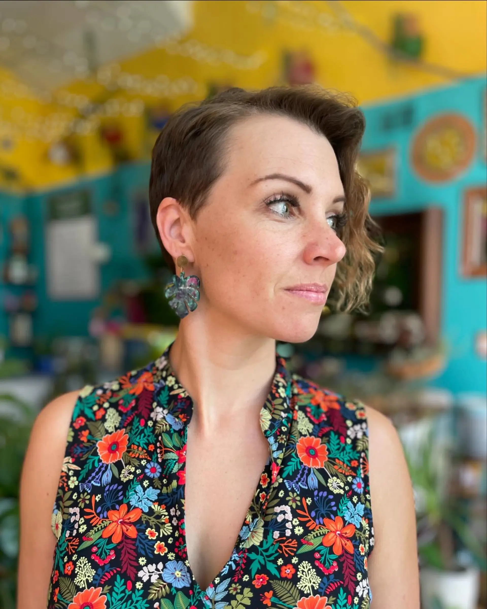 An asymmetrical short pixie cut with one side tapered closely and the other left longer with soft wavy texture. 1