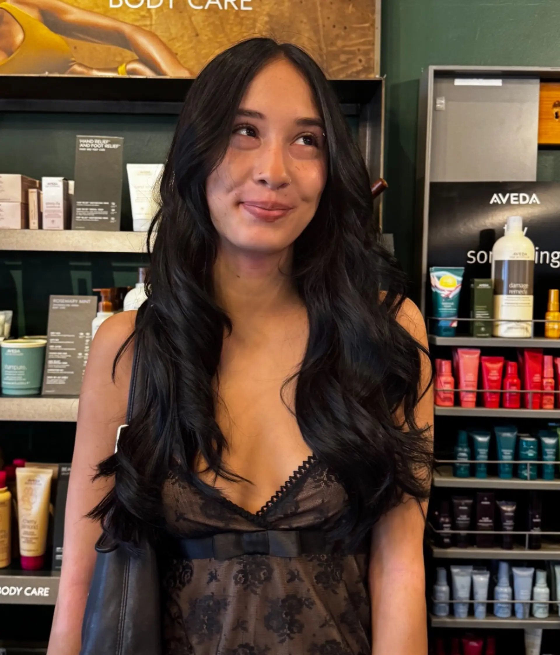 Center-parted long dark hair styled into voluminous, glossy waves with soft, polished ends. 1