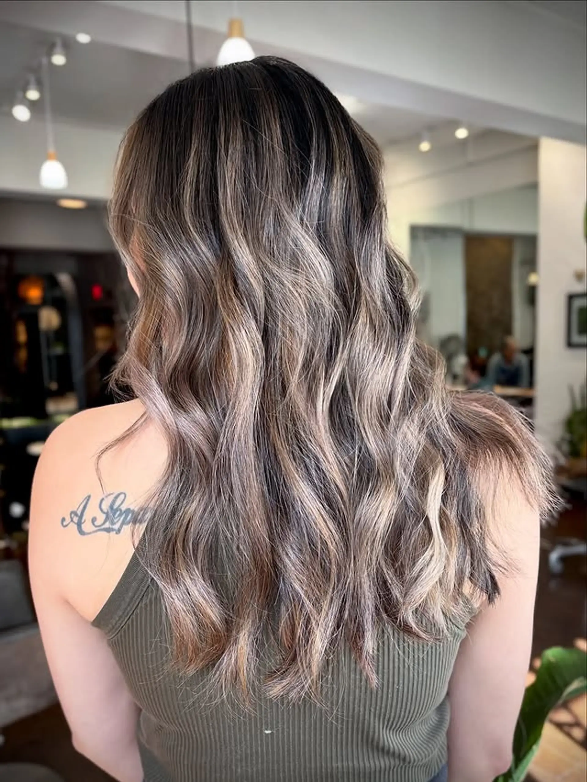 Long, wavy bronde balayage with a subtle blend of brown and blonde tones. 1