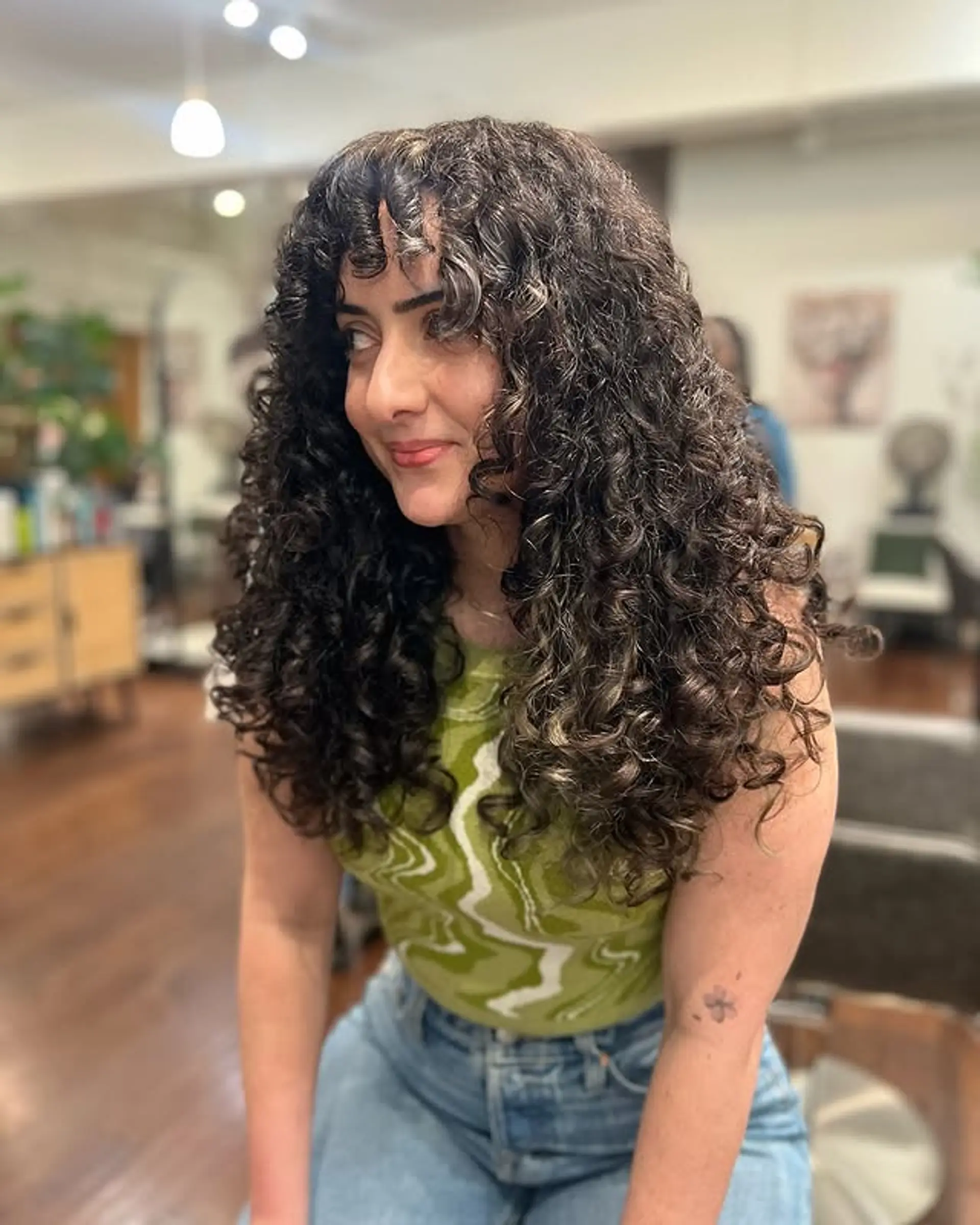 A trendy curly shag featuring a full fringe and lots of layering to enhance the natural curls and volume. 1