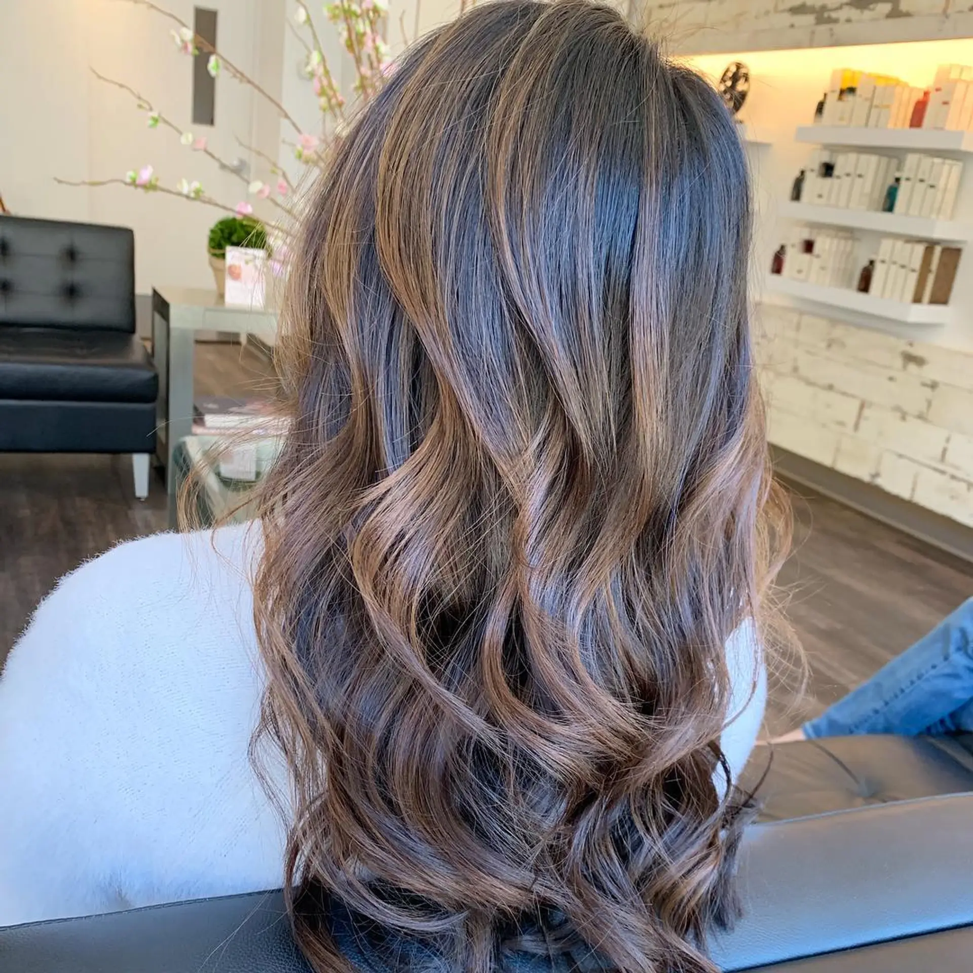 Long chocolate brunette hair with seamless warm balayage highlights styled in loose, textured waves. 1