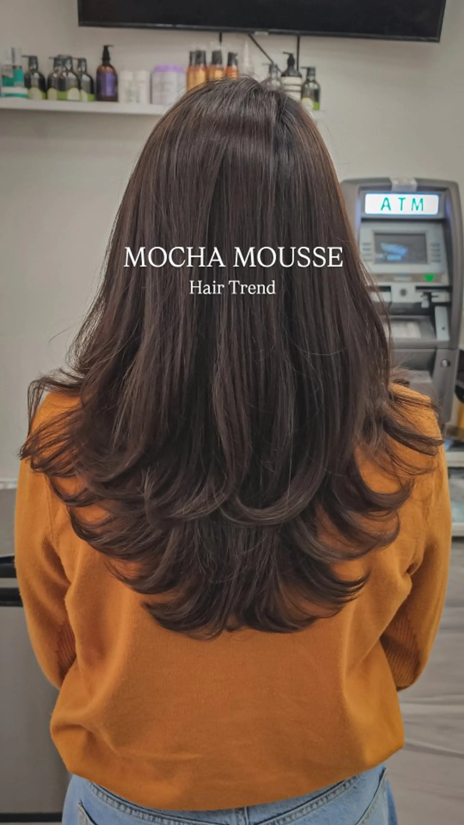 A rich mocha brunette long haircut with soft cascading layers and voluminous flipped ends. 1
