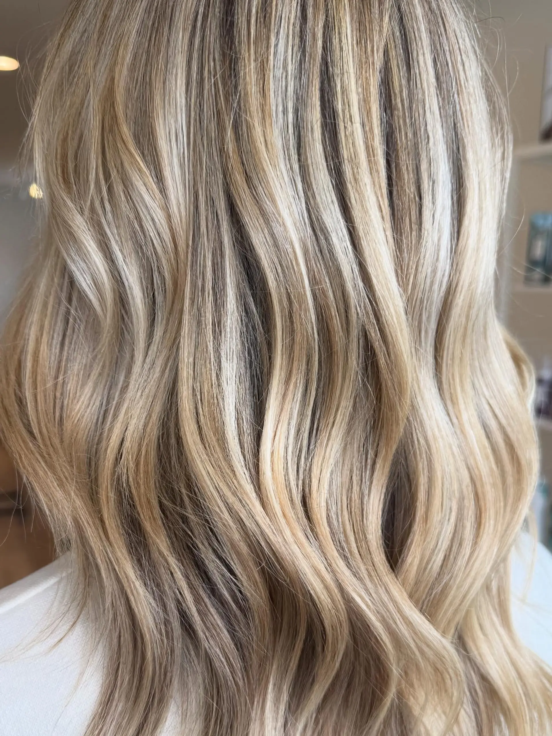 Medium-length dimensional blonde hair styled in soft, loose waves. 1