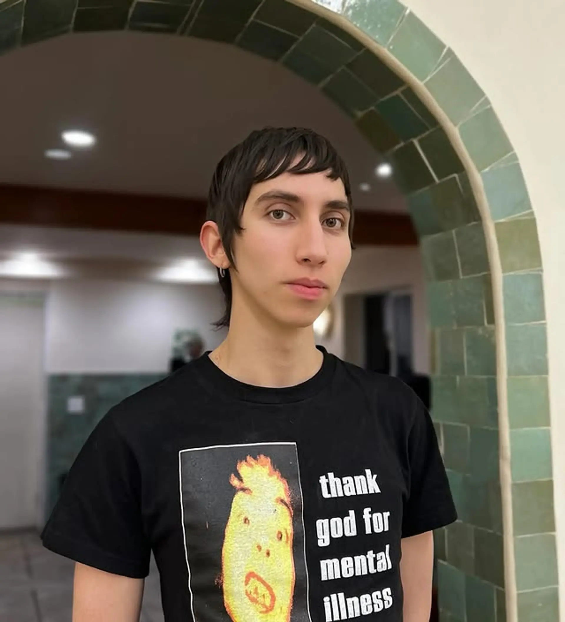 A modern mullet featuring short baby bangs and layered texture. 1