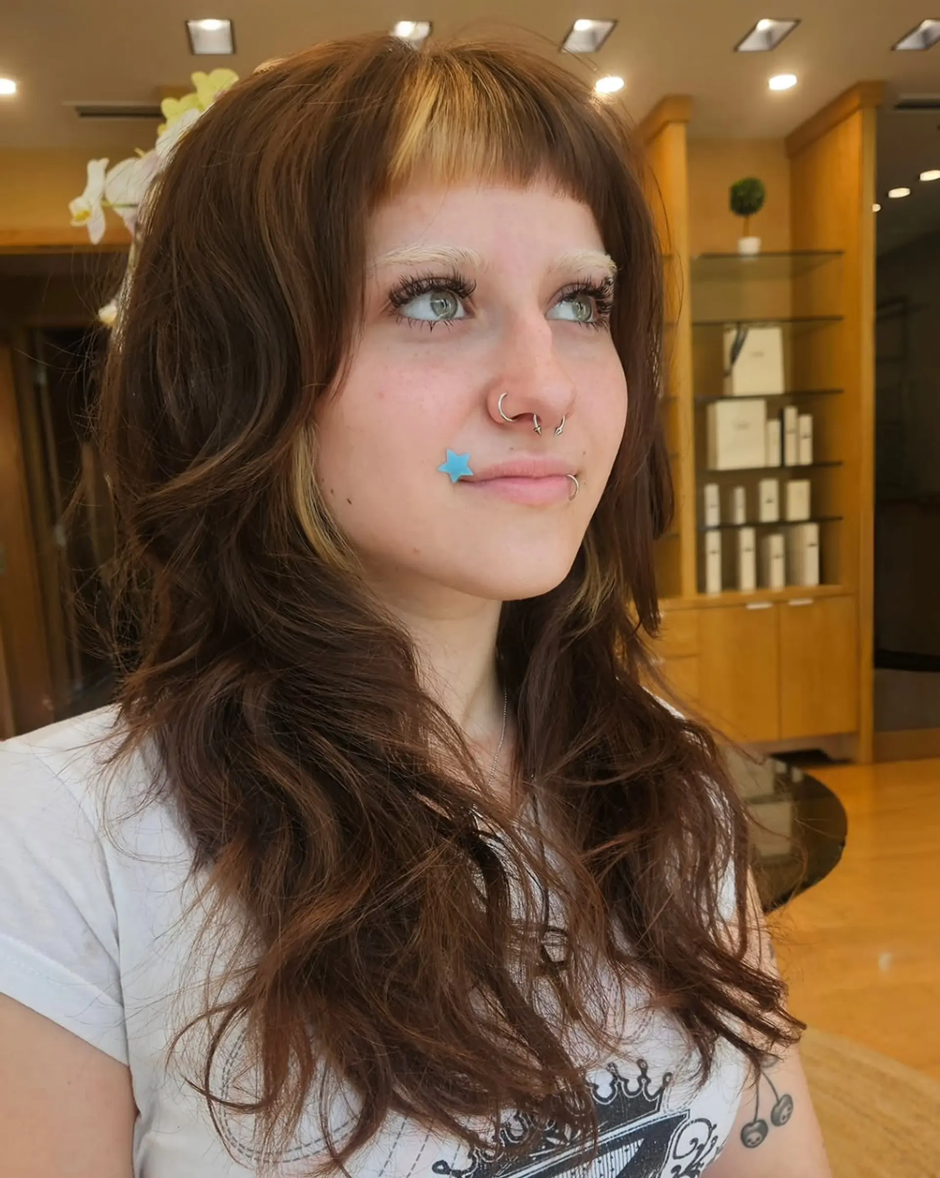 A trendy shag haircut with short, blunt baby bangs and face-framing layers. 1