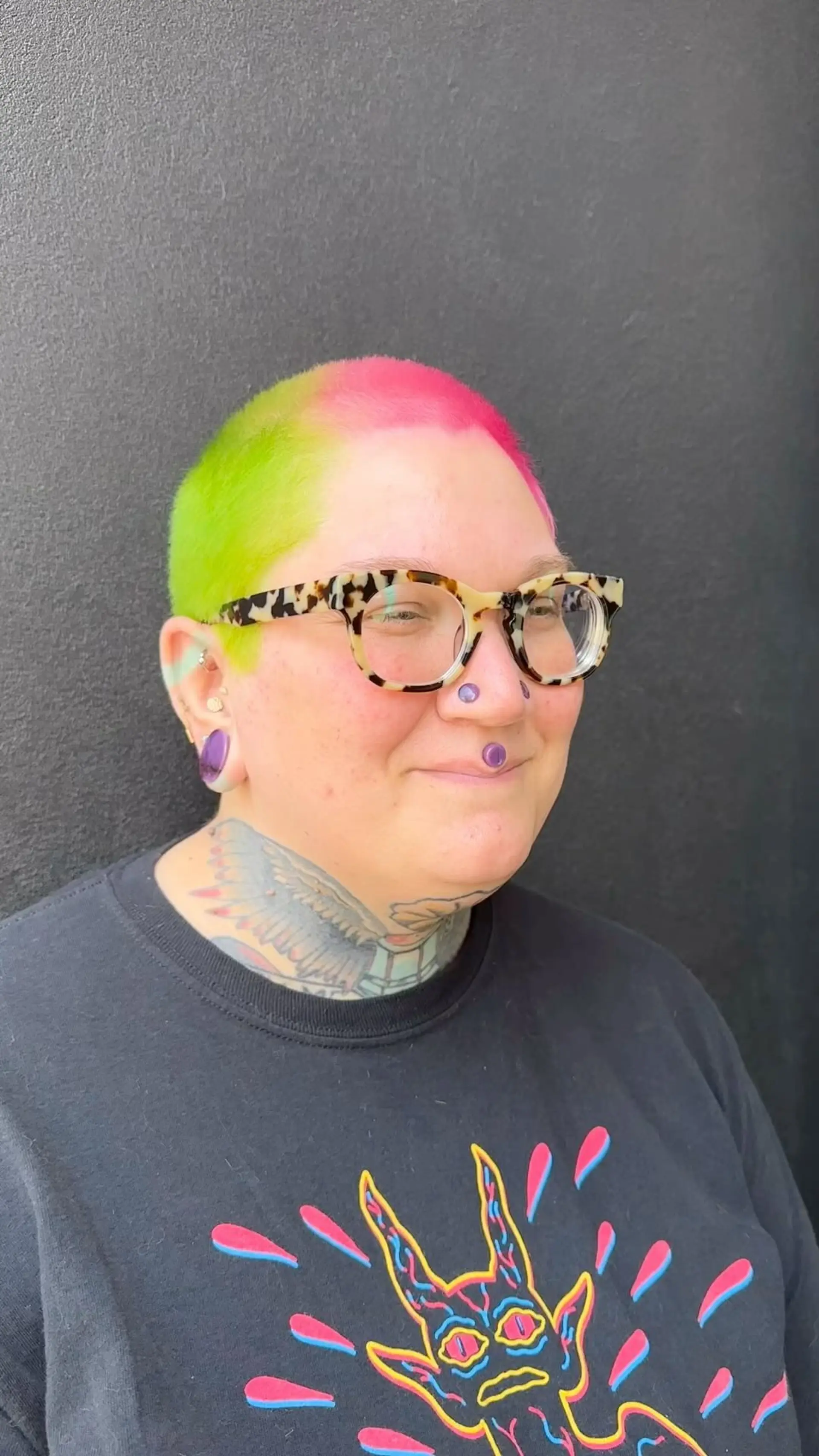 A vibrant split-color buzz cut featuring bright neon lime green on one side and vivid hot pink on the other. 1