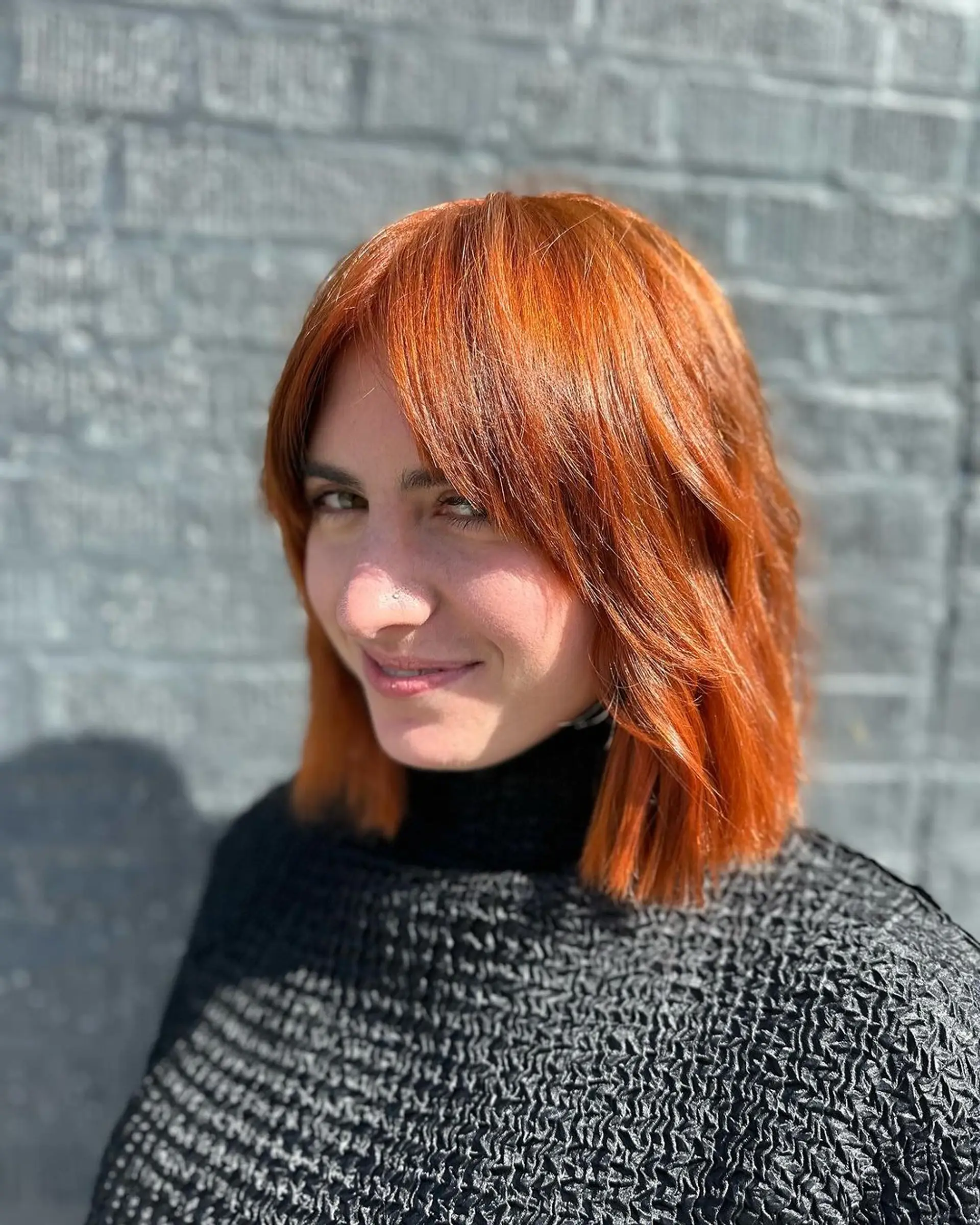 Medium-length copper and ginger waves with layered bob and face-framing bangs. 1