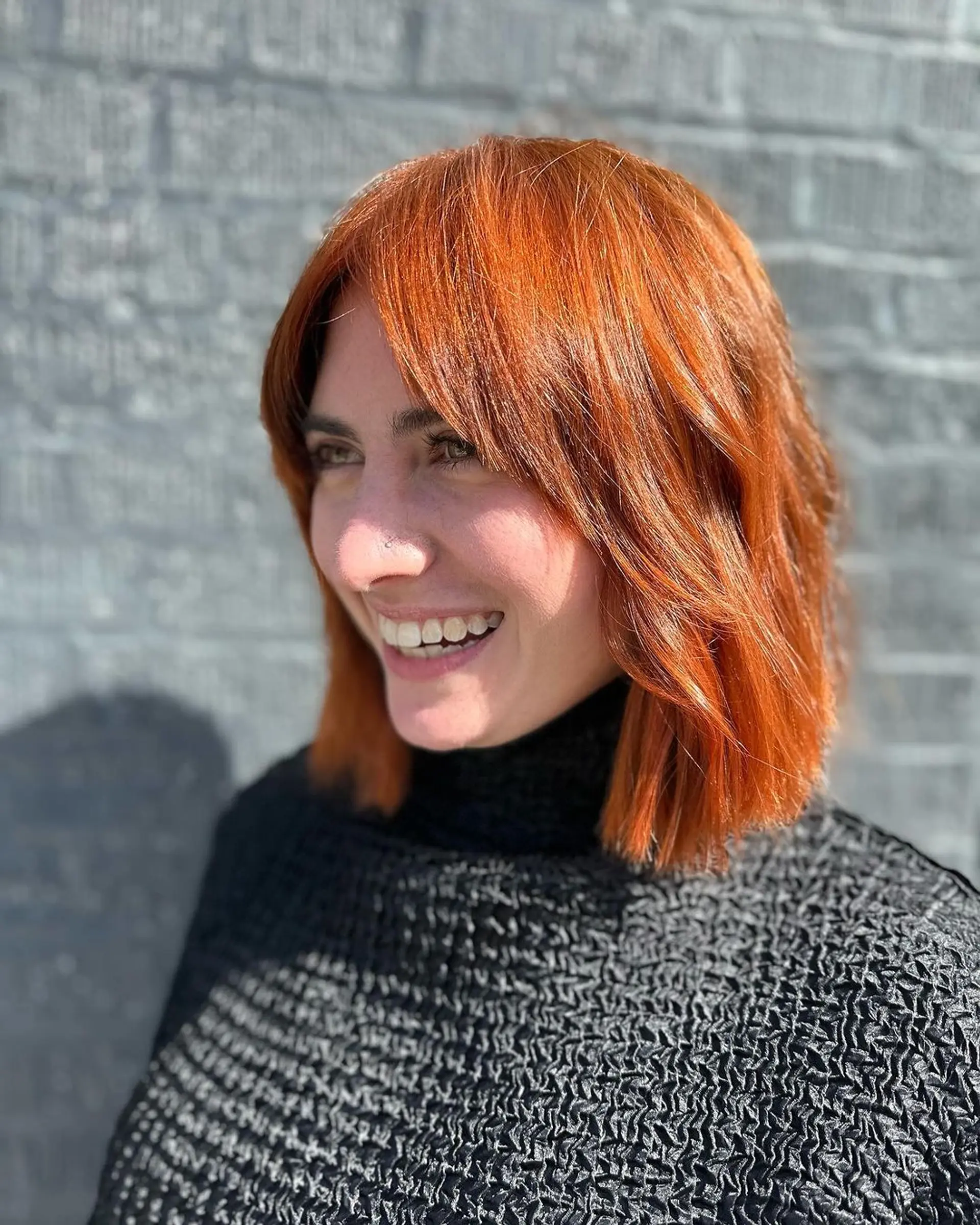 Medium-length copper and ginger waves with layered bob and face-framing bangs. 2