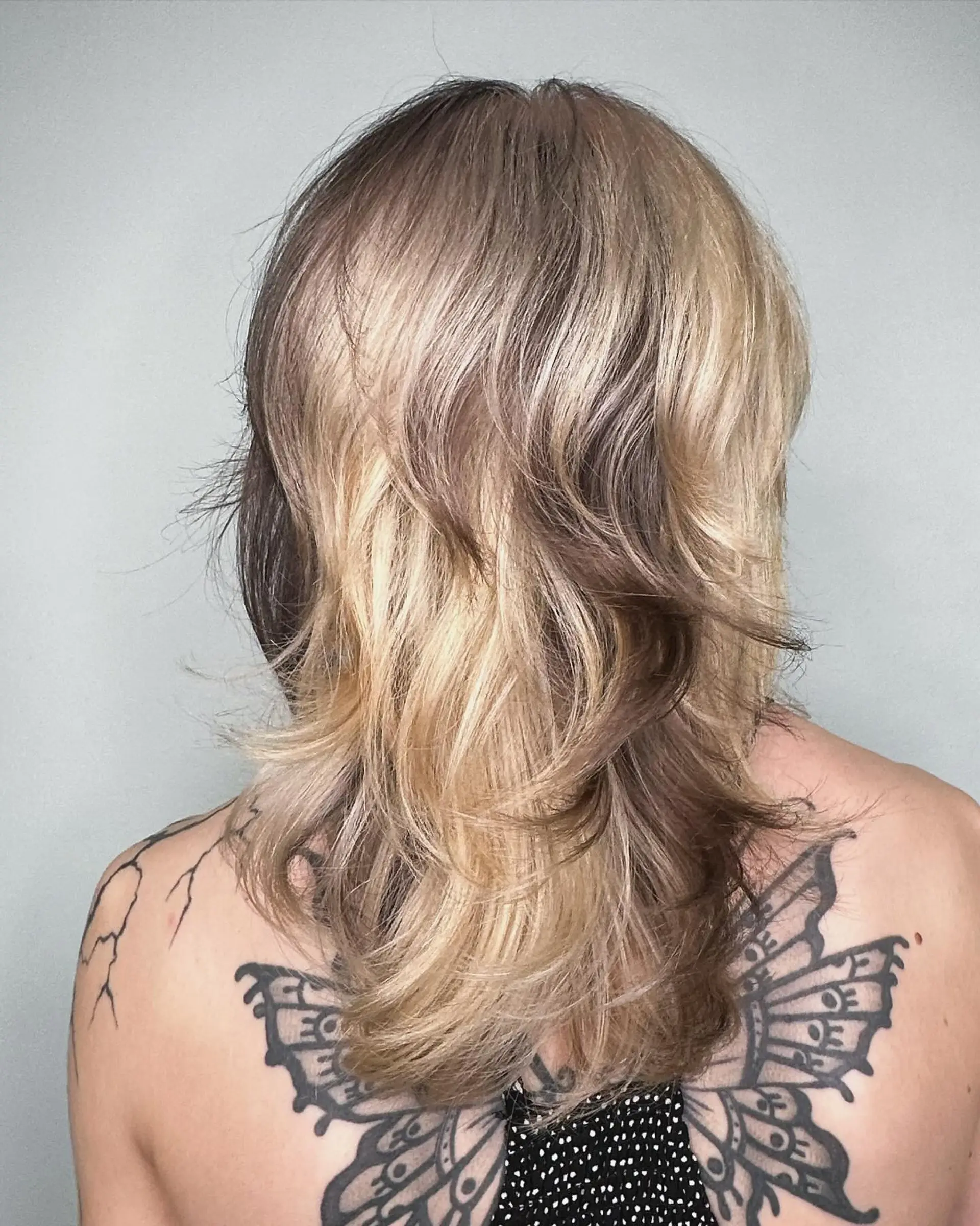 A medium-length layered shag haircut featuring distinct contrasting panels of warm blonde and soft brown with flicked, feathered ends. 1