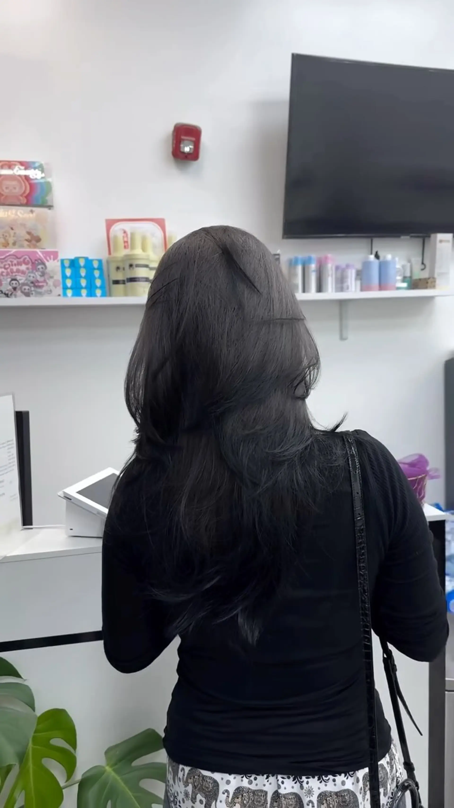 Long cool-toned deep brunette hair cut in feathered layers that frame softly and flip slightly outwards at the mid-lengths and ends. 1