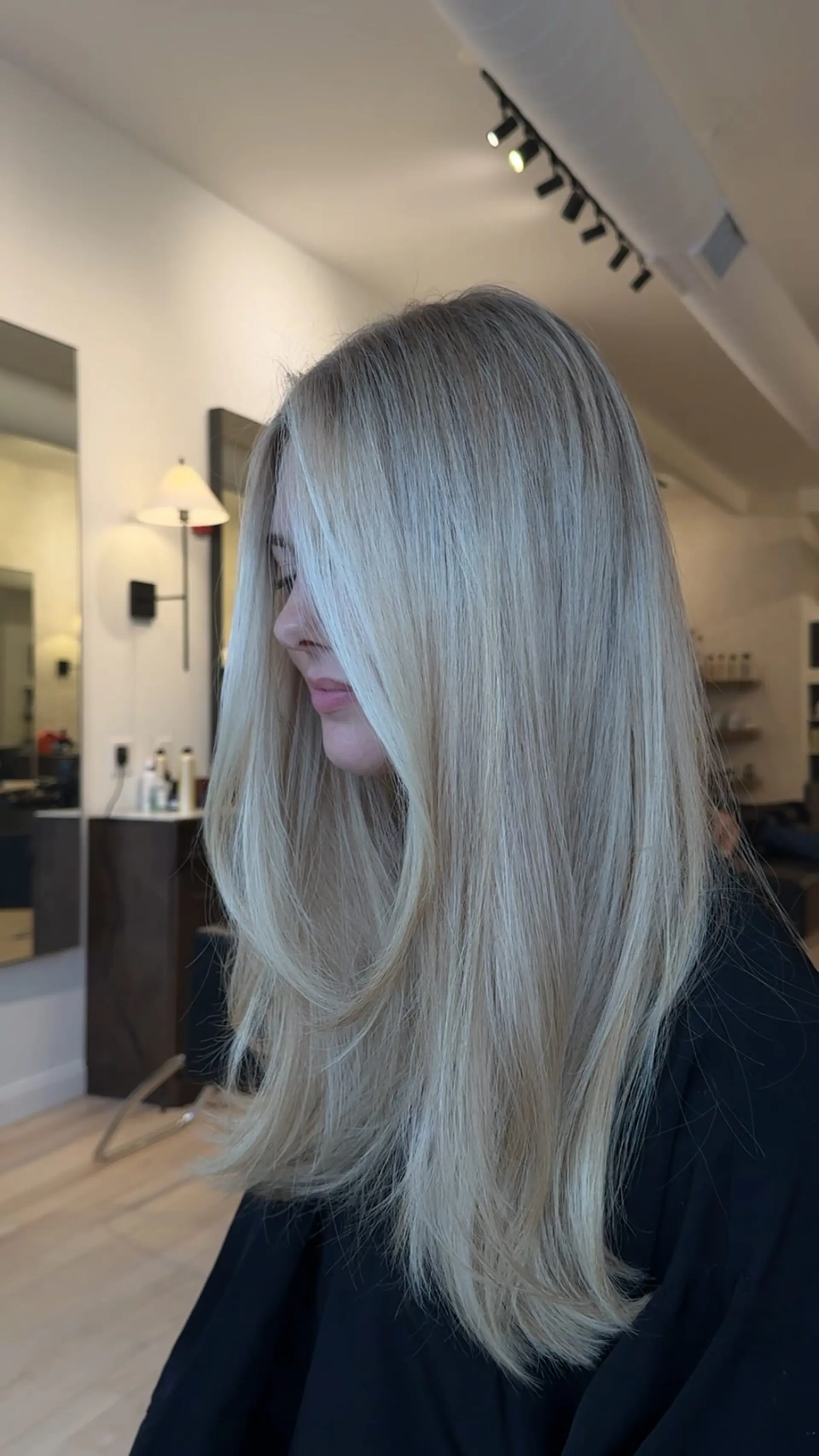 Long, straight cool blonde hair featuring soft face-framing layers and a polished blowout finish. 1