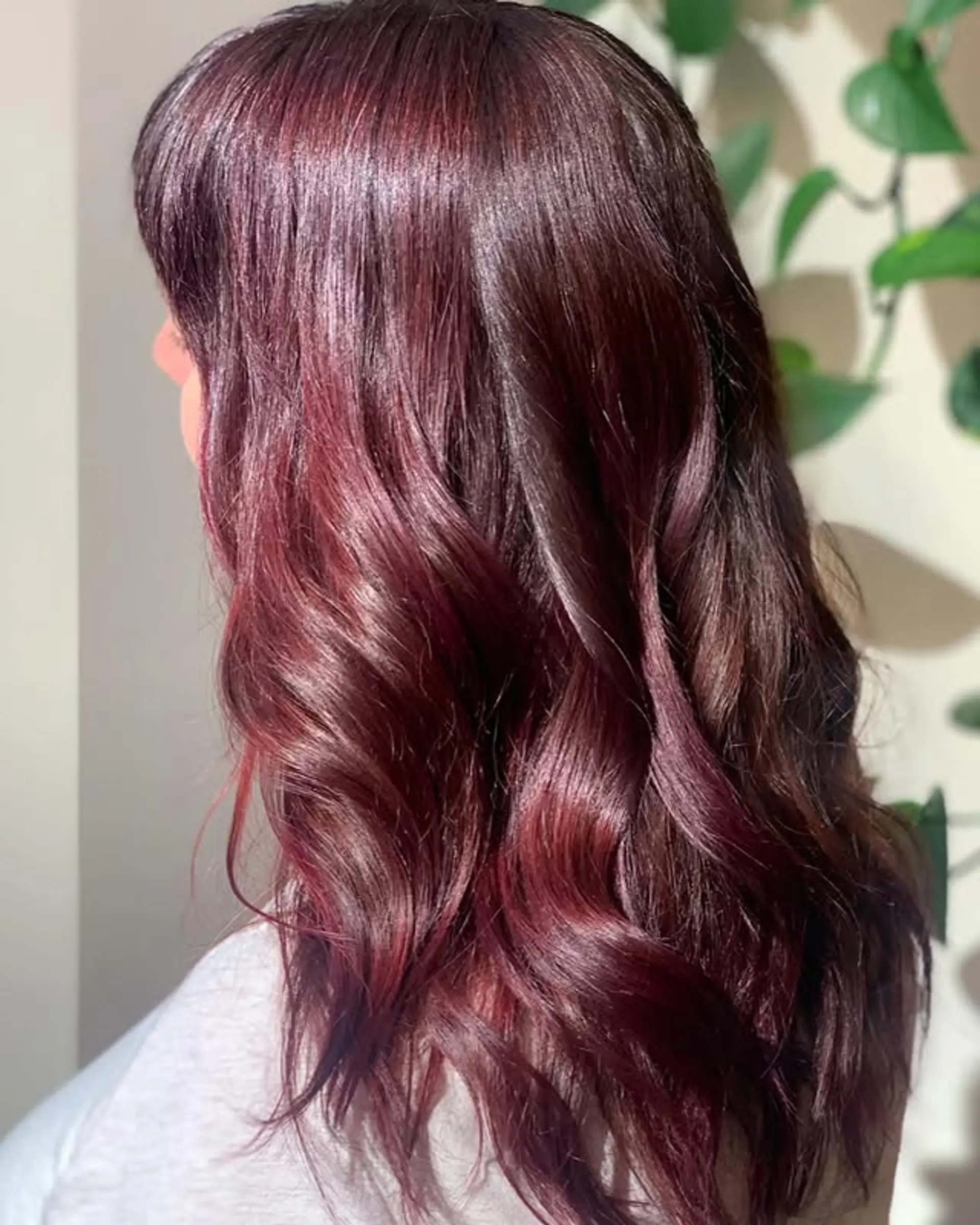 Long, wavy hair with bangs, styled in a rich burgundy color with subtle auburn highlights. 1