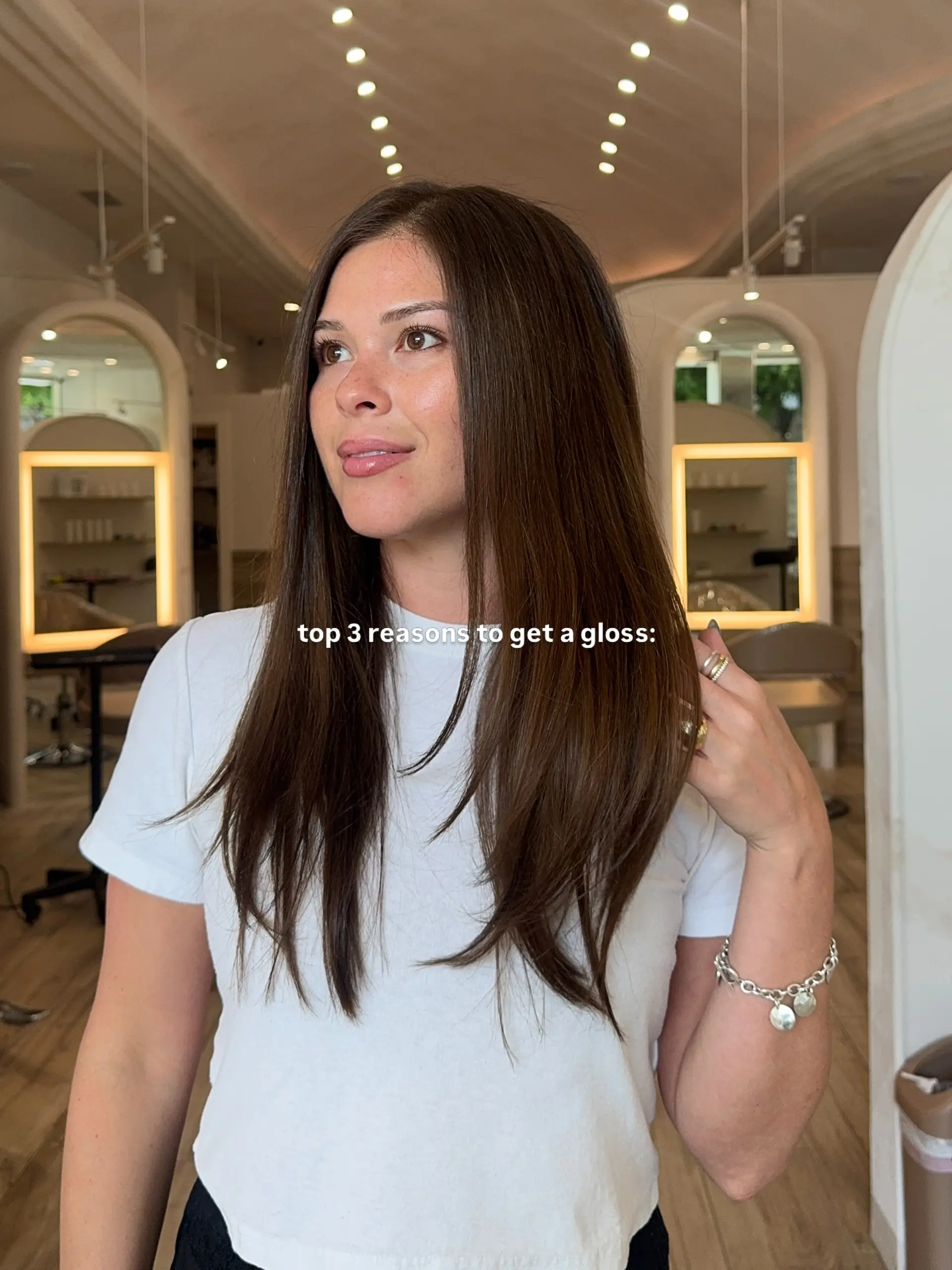 Long, radiant brunette hair styled sleek and straight with softly tapered layers and a smooth blowout finish. 1