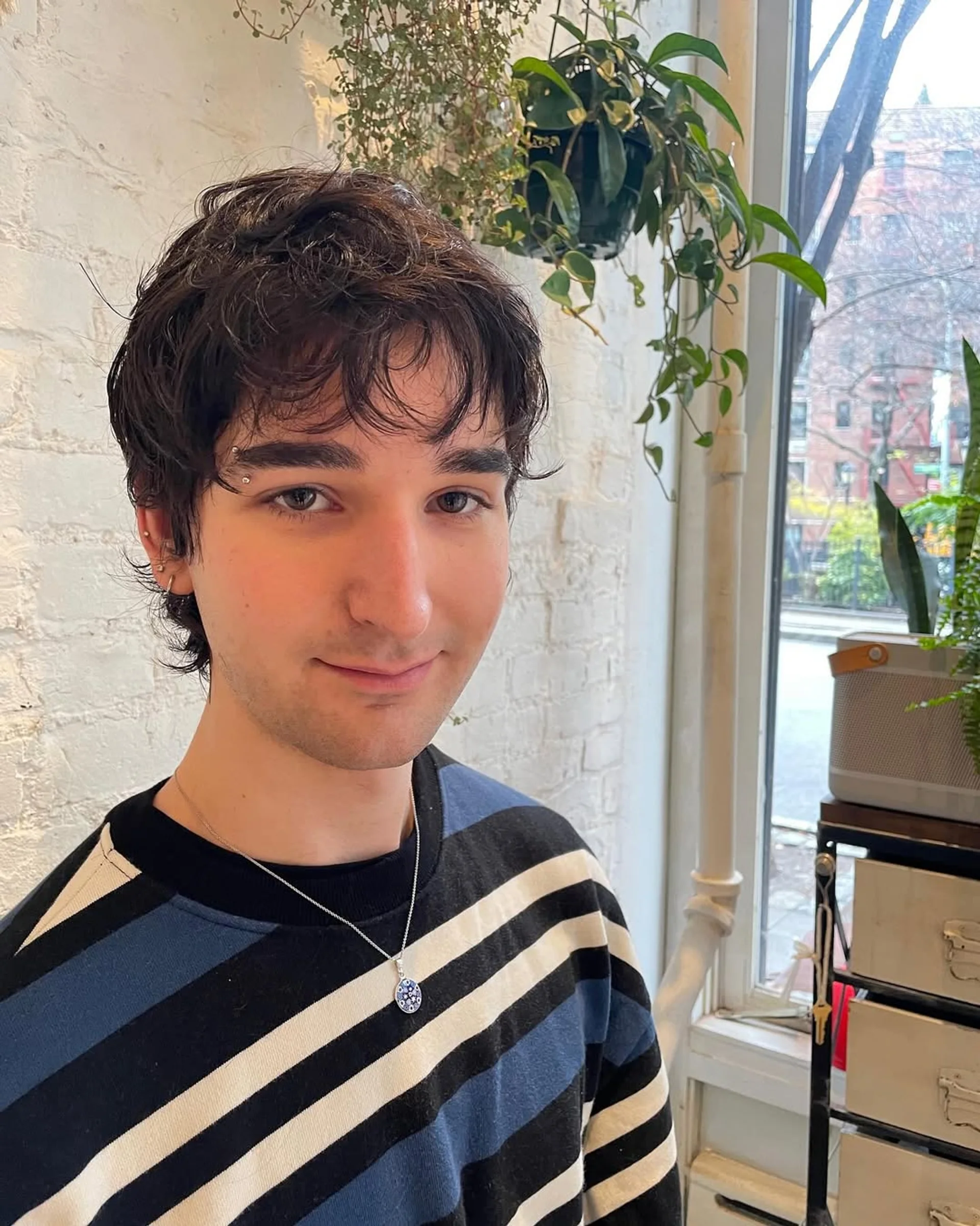 A man with a modern textured crop haircut with natural waves, showcasing a stylish and effortless look in a NYC salon. - Preview 1