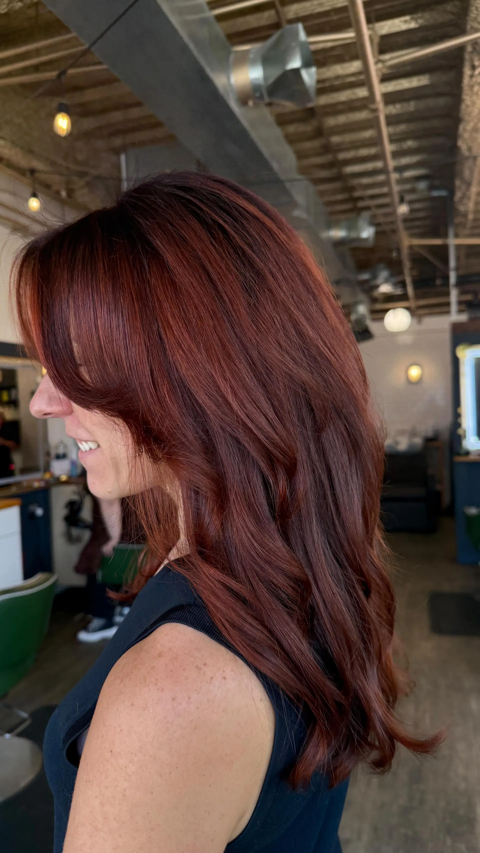 Rich auburn red hair with flowing face-framing layers and styled with a smooth, voluminous blowout. 1