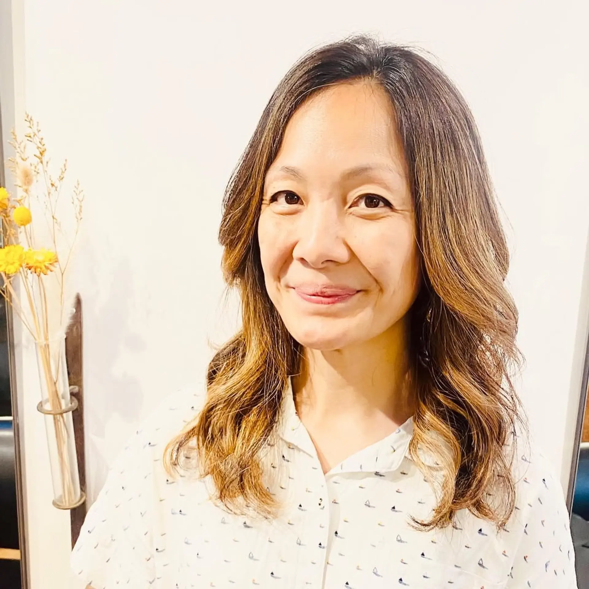 A wavy, medium-length hairstyle with a bronde balayage, creating a sun-kissed effect. 1