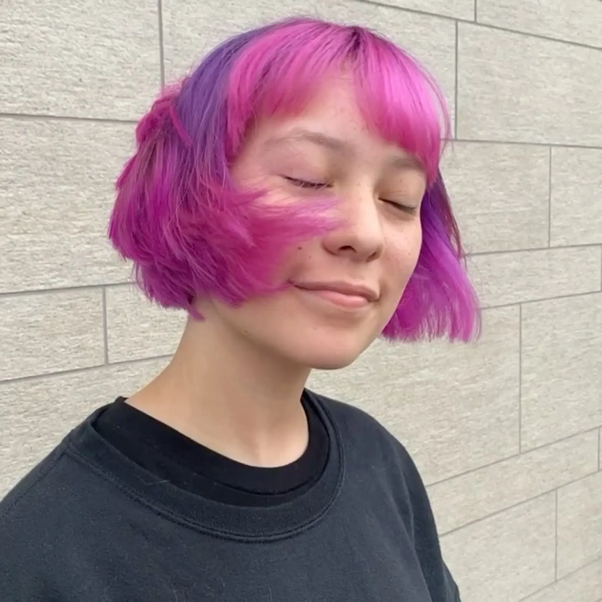 A textured chin-length blunt bob with fringe, styled in bright magenta pink and purple tones. 1