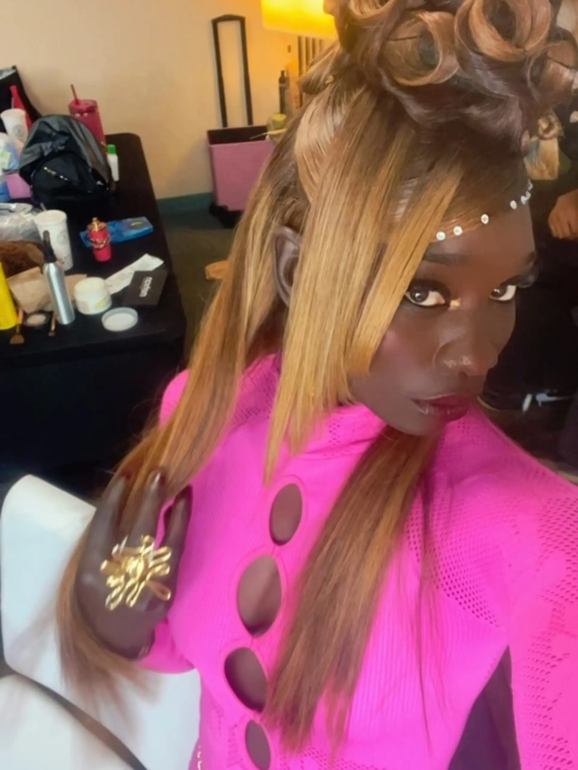 A dramatic 90s-inspired sculpted updo featuring rolled pin curls atop the head with sleek, angled side-swept fringe and hairline rhinestone accents. 1