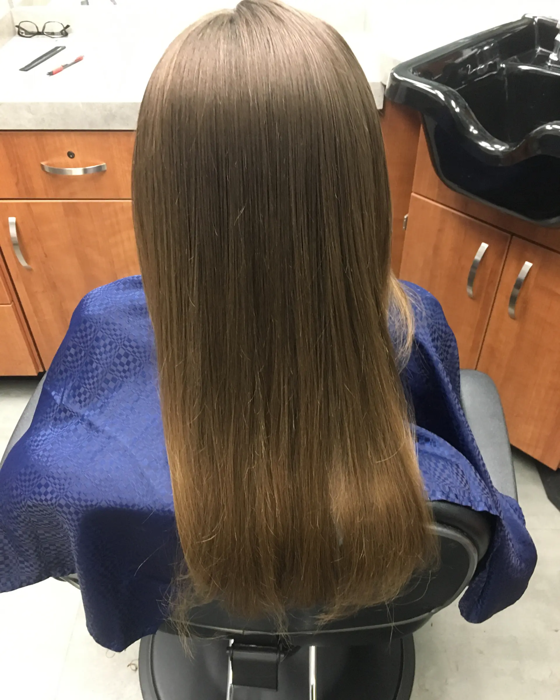 Smooth, sleek straight light brown hair styled evenly down the back. 1
