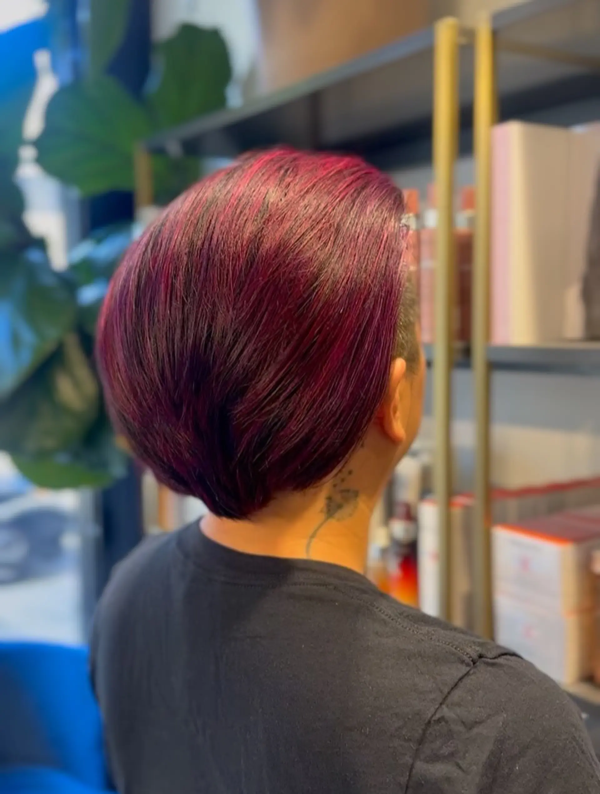 A sleek, tapered short cut featuring a rich blend of magenta, red, and purple creative fashion colors swept neatly backward. 1
