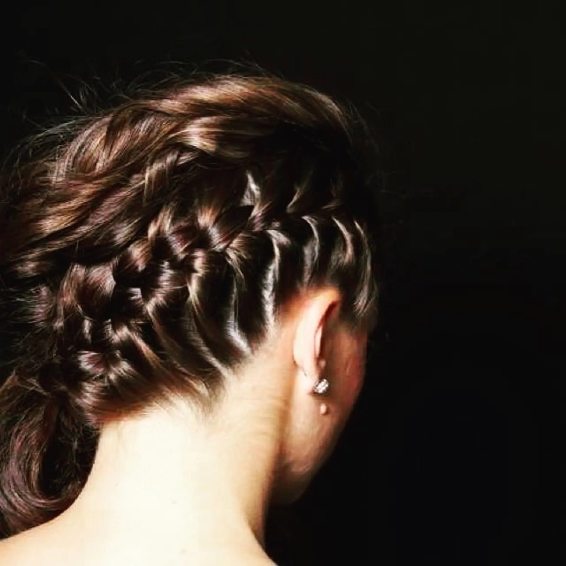 An intricate braided updo featuring a deep side Dutch braid wrapping cleanly along the contours of the head. 1