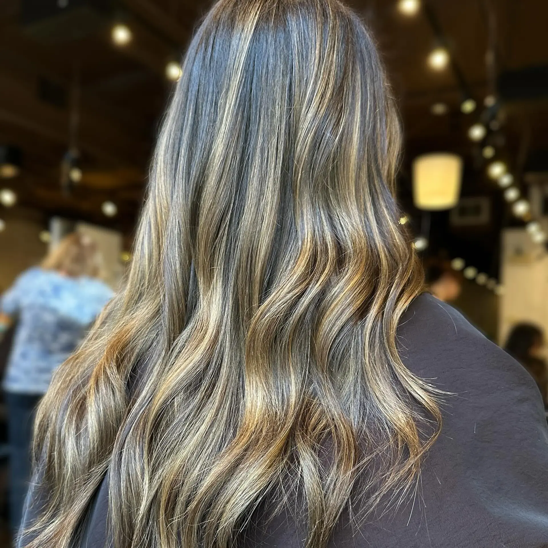 Long, wavy hair with a bronde balayage for a dimensional and trendy look. 1