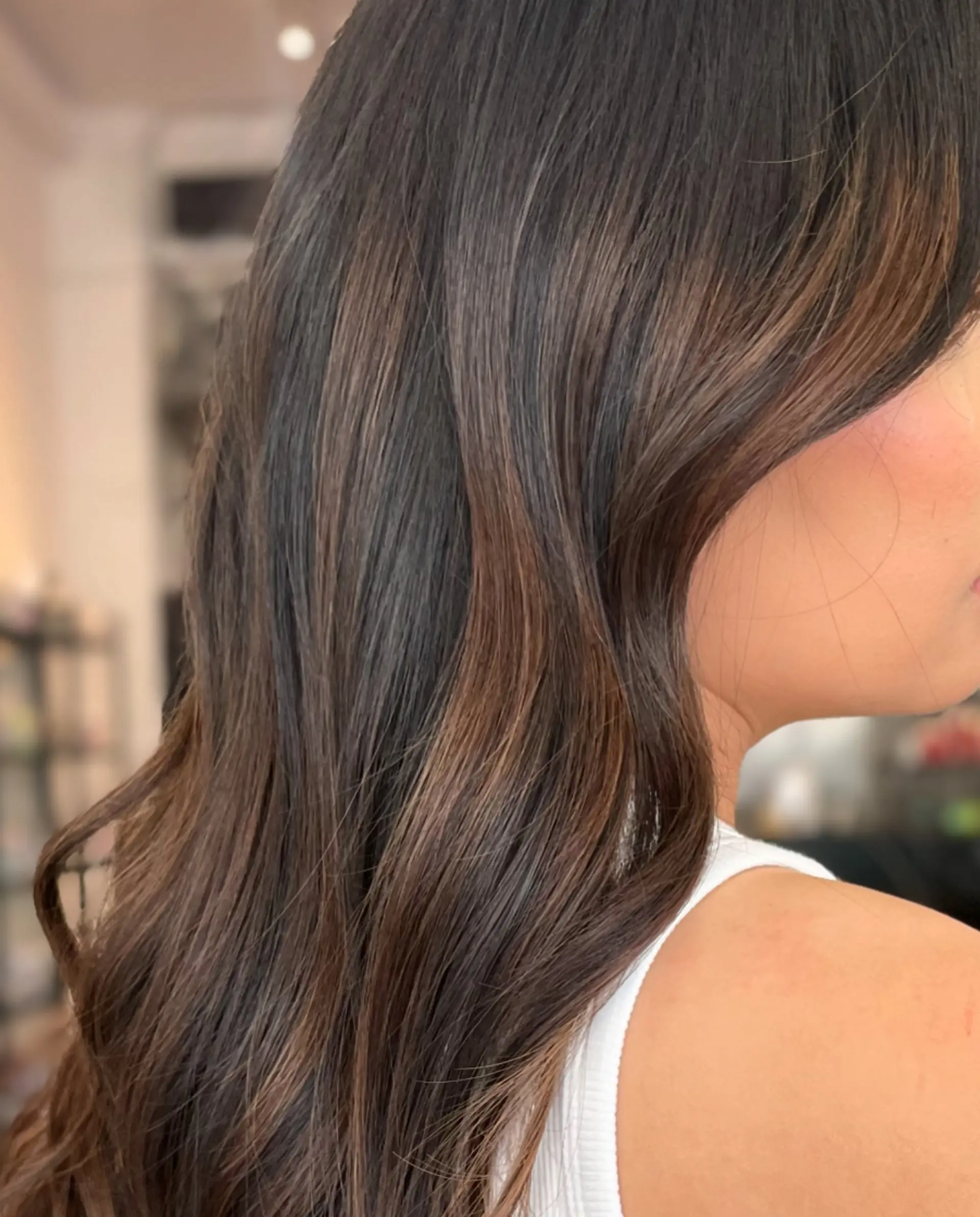 Long dimensional chocolate brown hair featuring soft, layered waves. 1