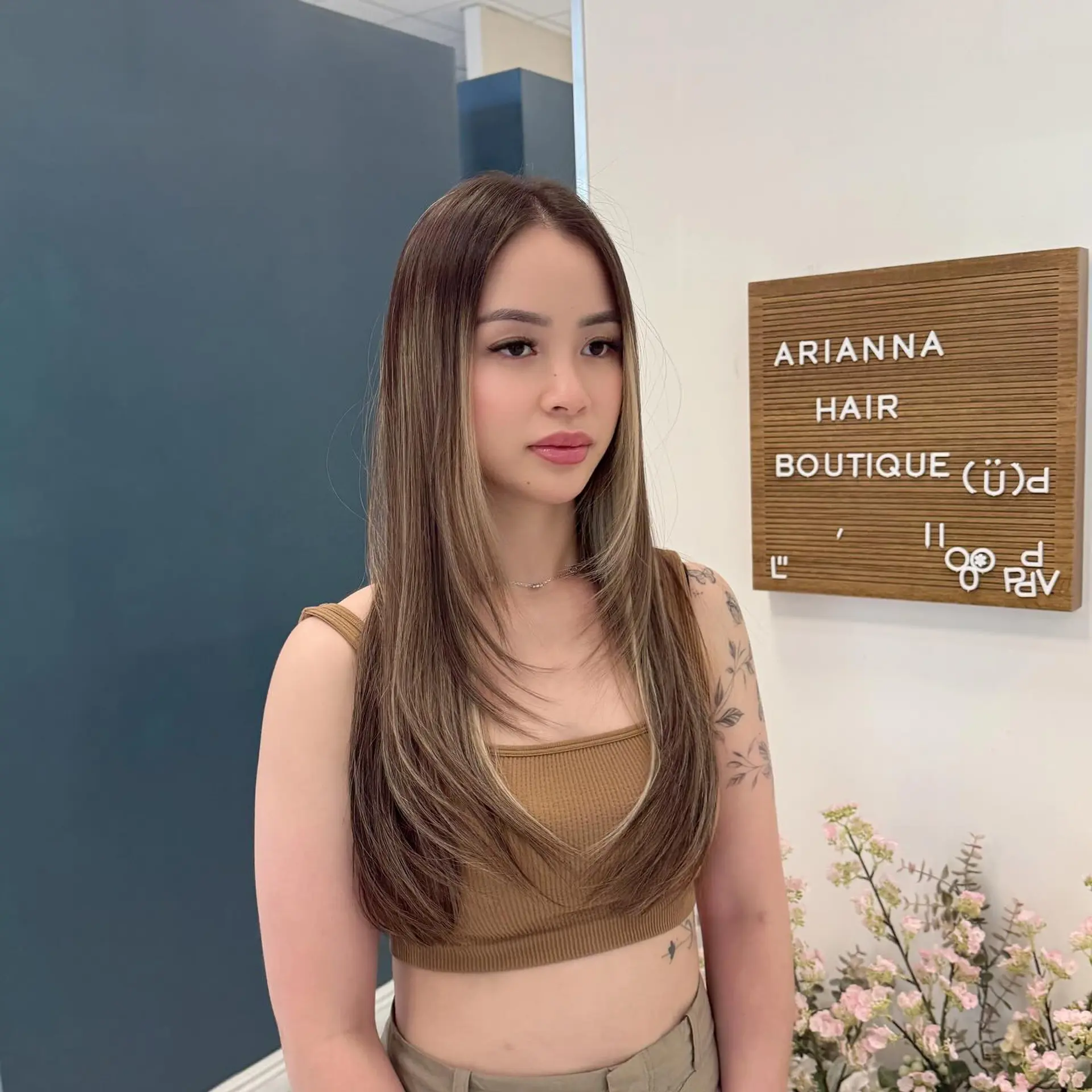 Long straight brown hair cut into cascading layers with bright blonde face-framing highlights and softly curved ends. 1