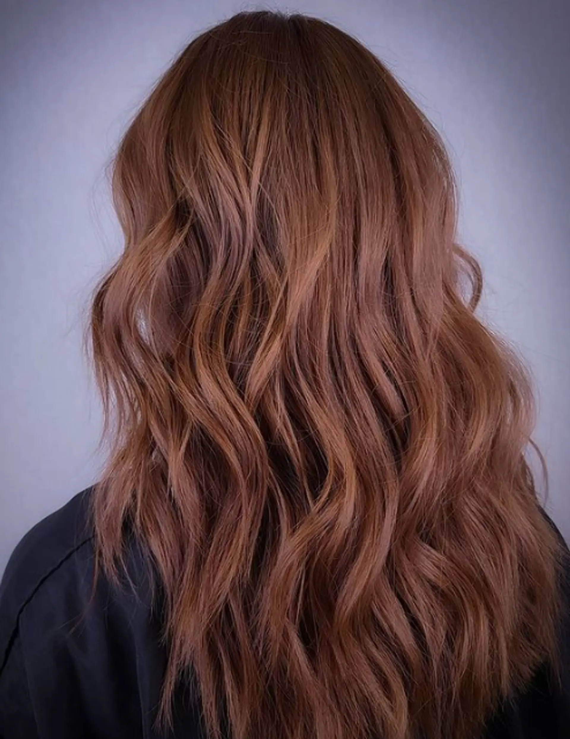 Long, wavy, auburn hair with natural, loose beach waves and layered cut, adding dimension and volume. 1