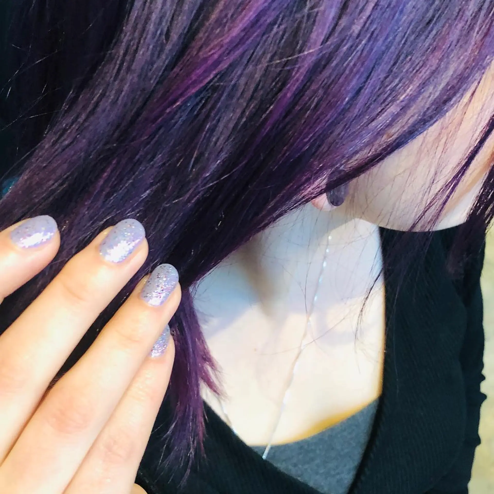 Straight, medium-length dark hair with vibrant purple and violet highlights. 1