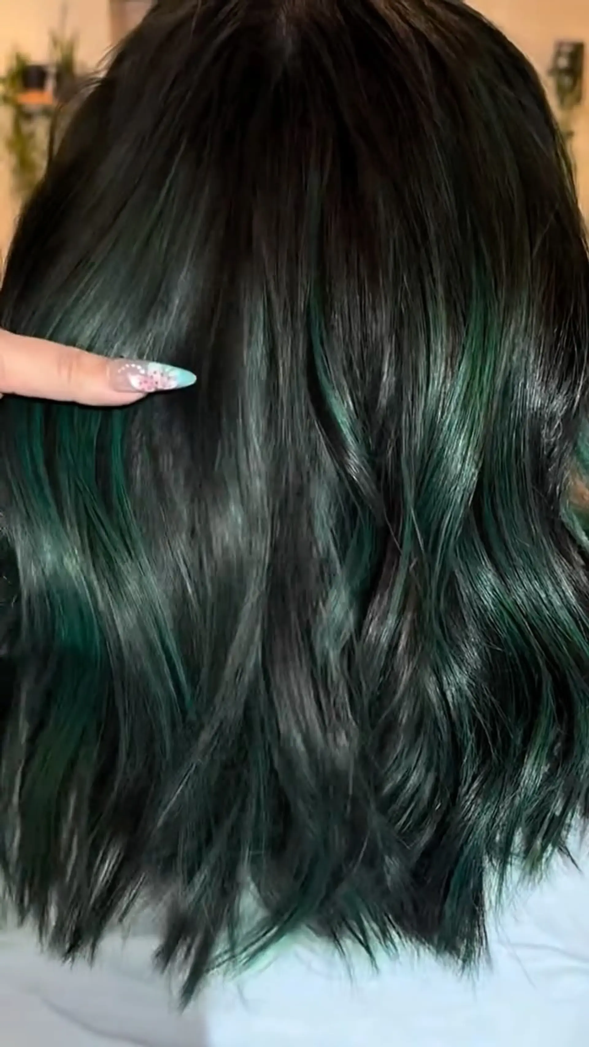 Medium-length textured waves in deep black accented with rich emerald and forest green ribbons of color. 1