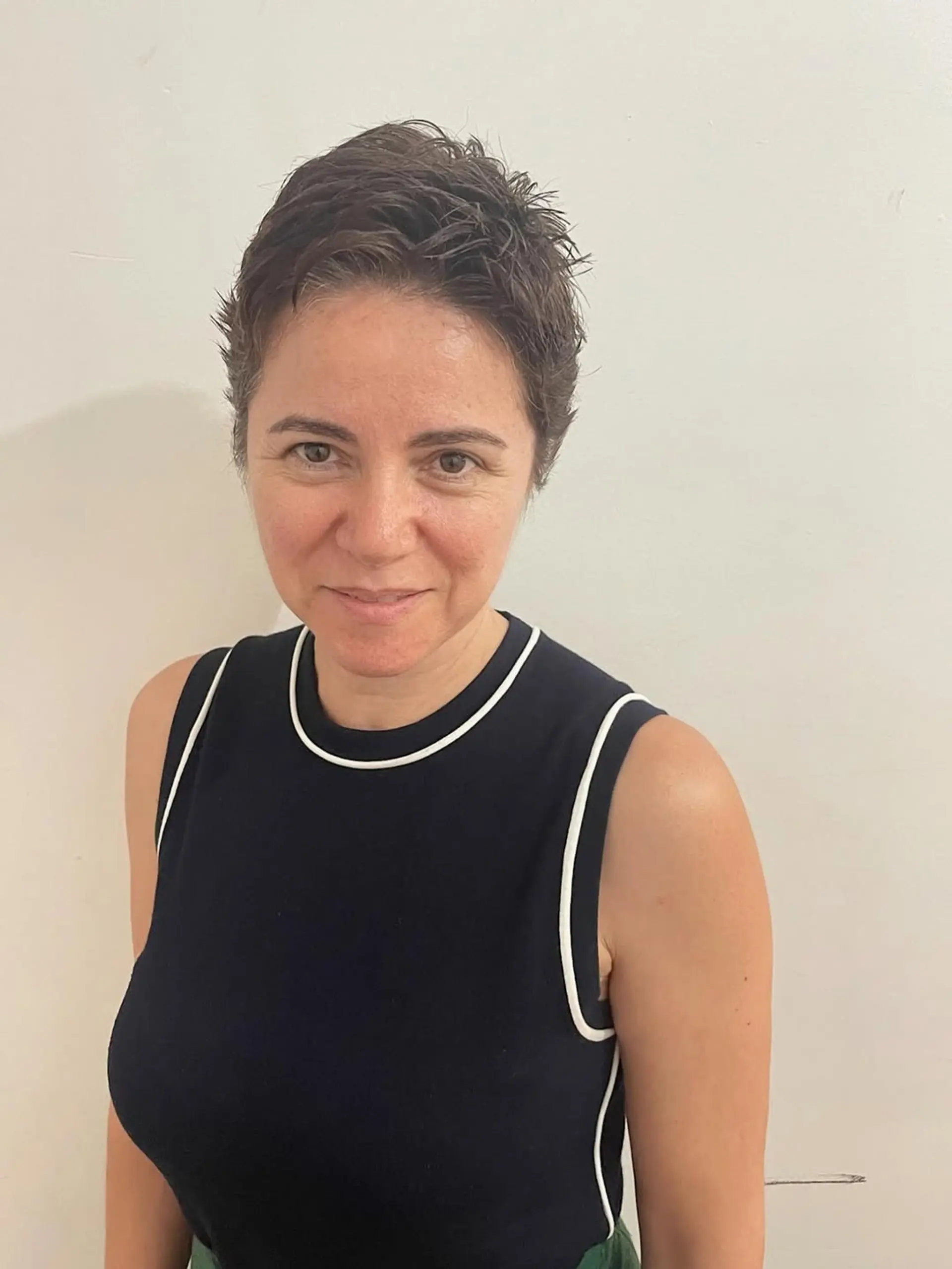 A modern, very short textured pixie cut, characterized by spiky layers on top that create volume and an edgy, dynamic silhouette. The sides are kept shorter, blending into the textured crown. 1