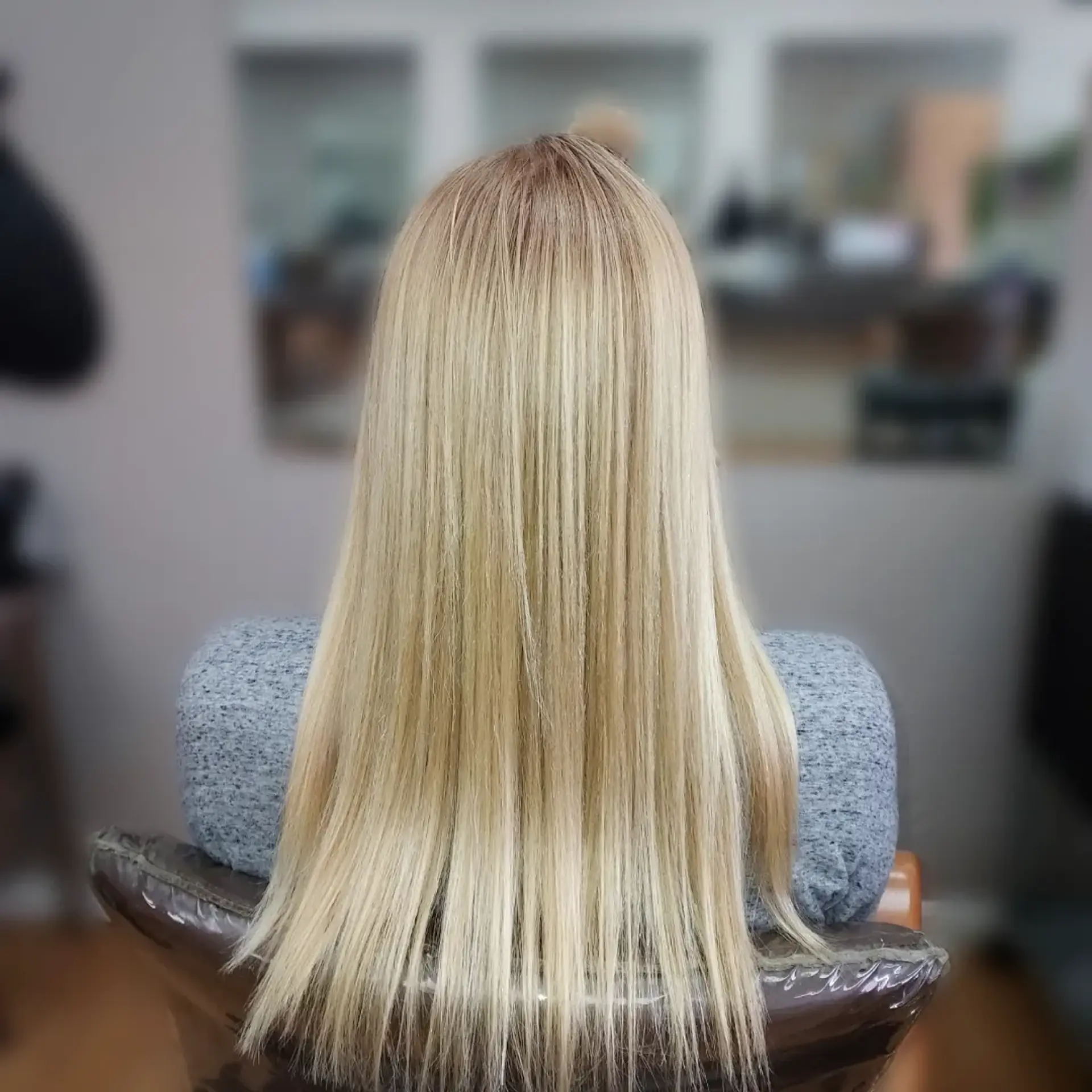 Silky, pin-straight light blonde hair flowing smoothly down to mid-back length with a clean finish. 1