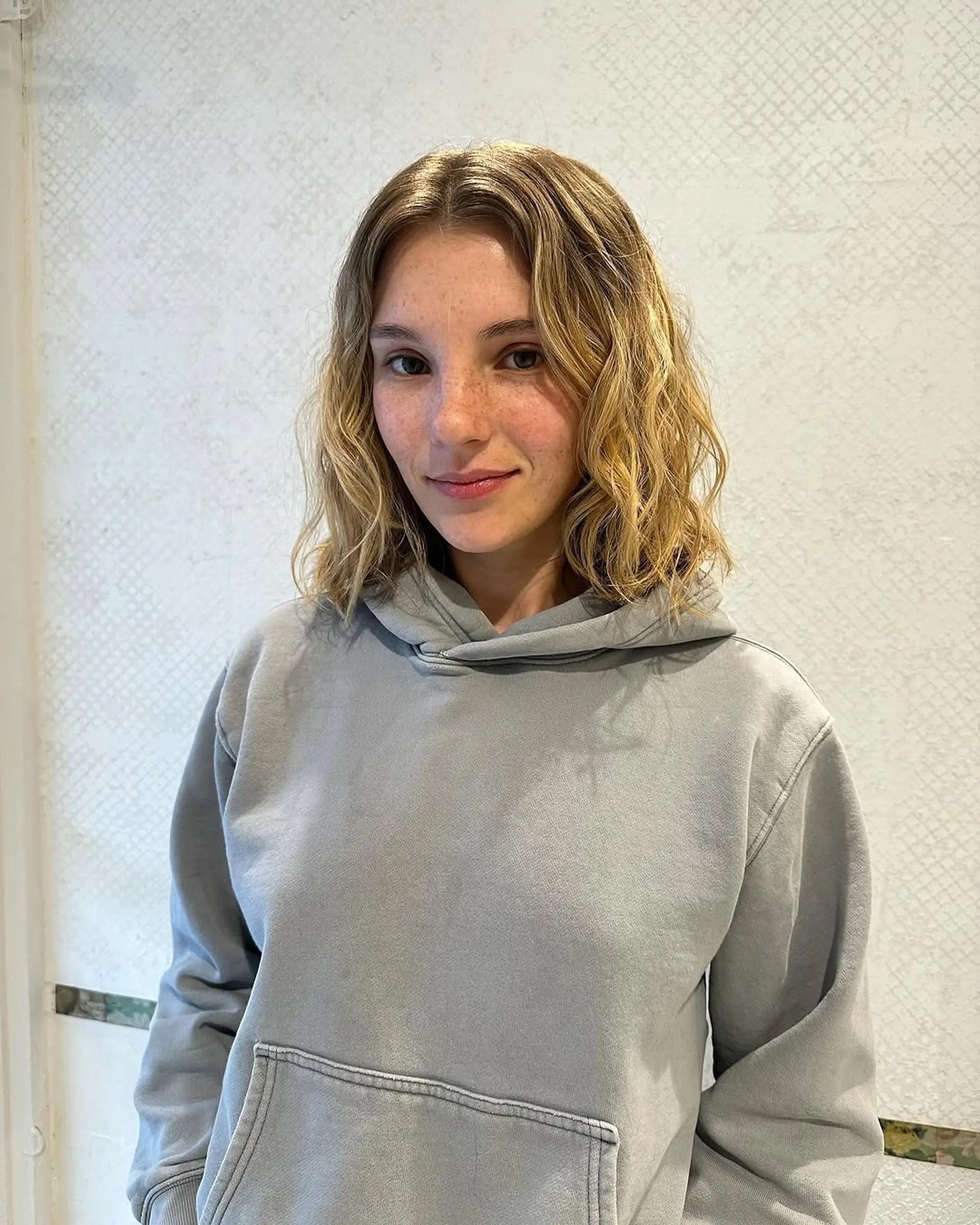 Wavy, medium-length hair with a blend of blonde and light brown hues. Features natural waves with face-framing layers and warm tones. 2