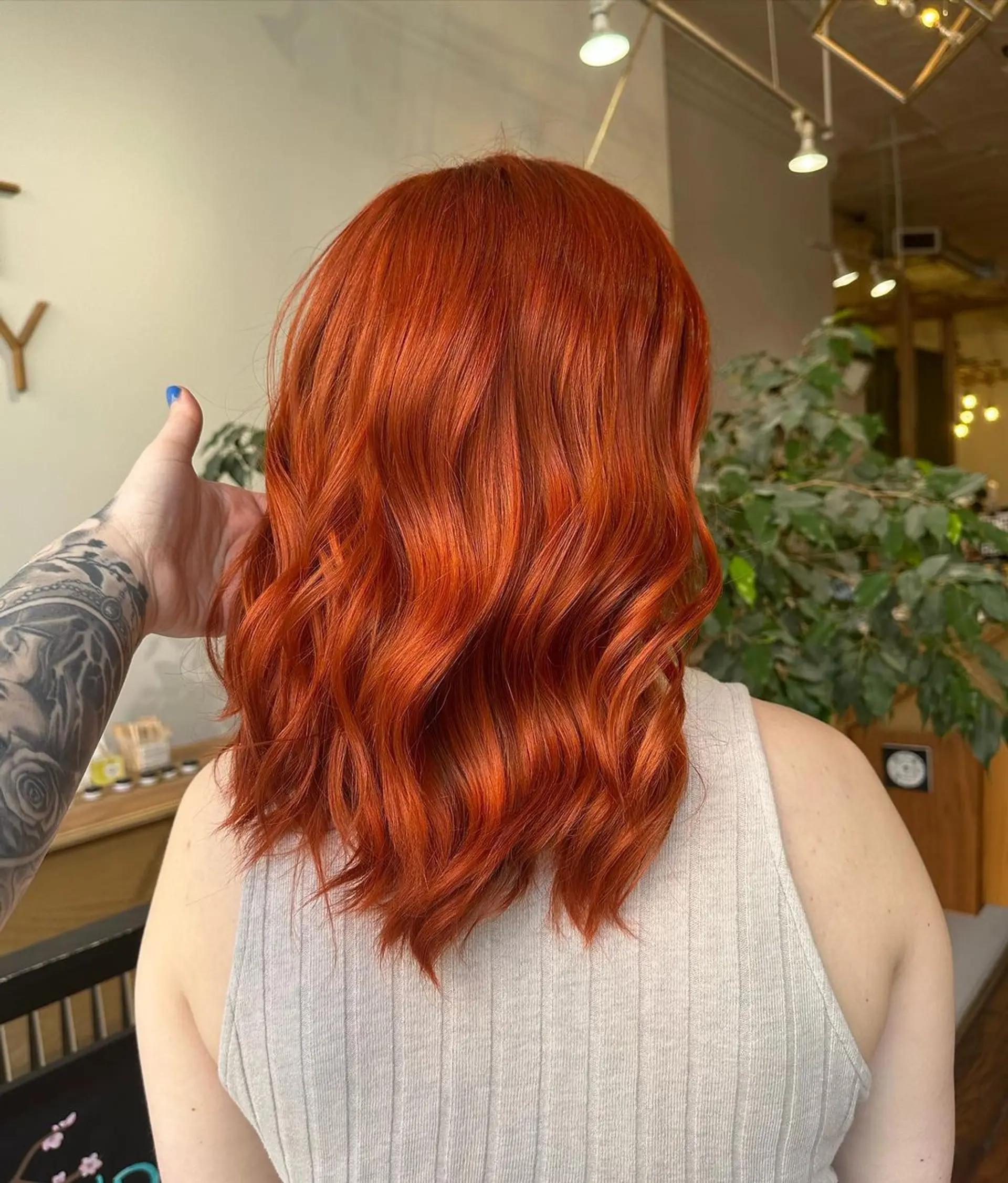Medium-length, wavy hair with vibrant red and fiery orange hues, styled in loose, flowing waves with layers. 1