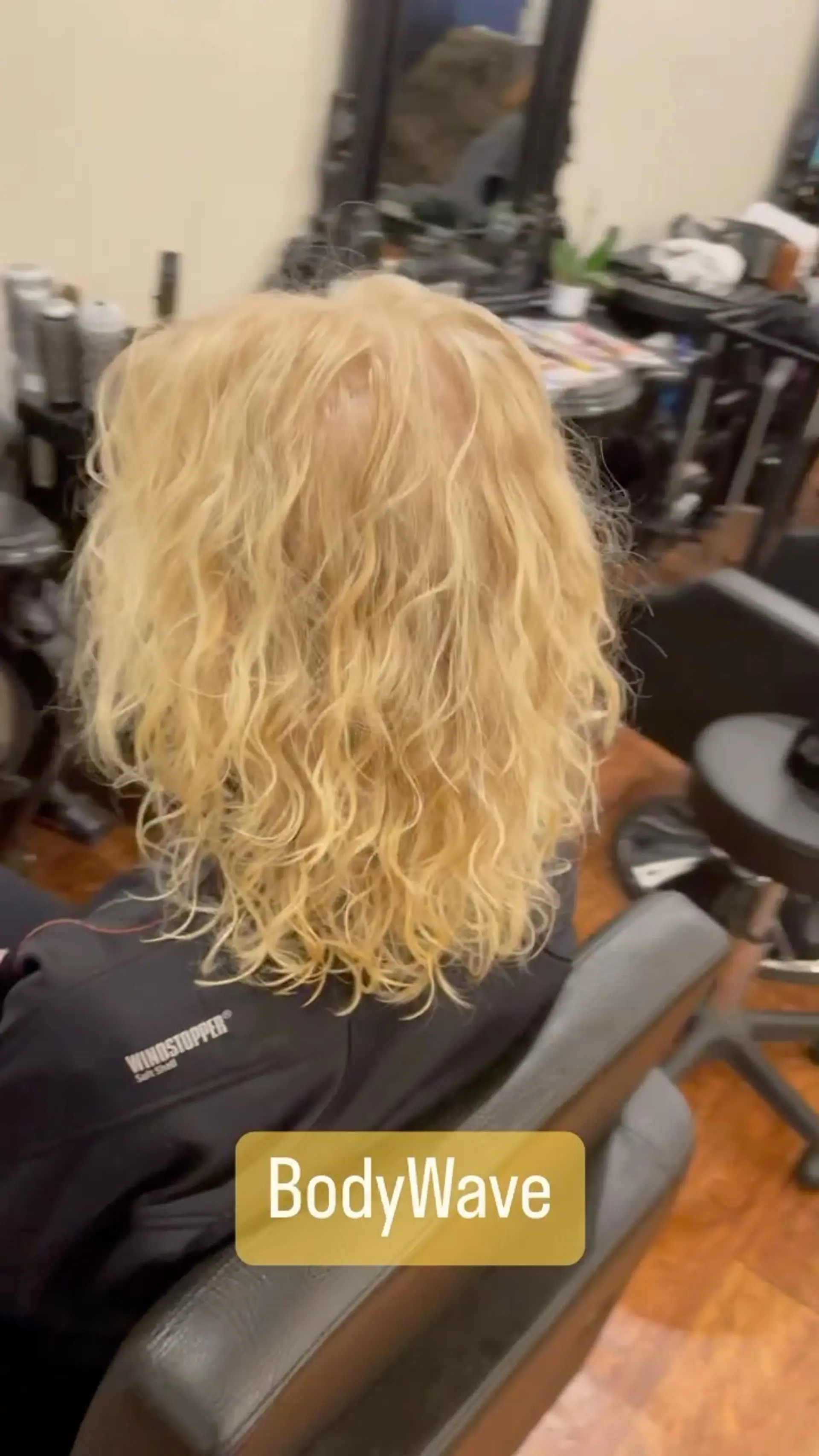 Shoulder-length blonde hair styled with soft, defined body wave permed curls for added texture and volume. 1