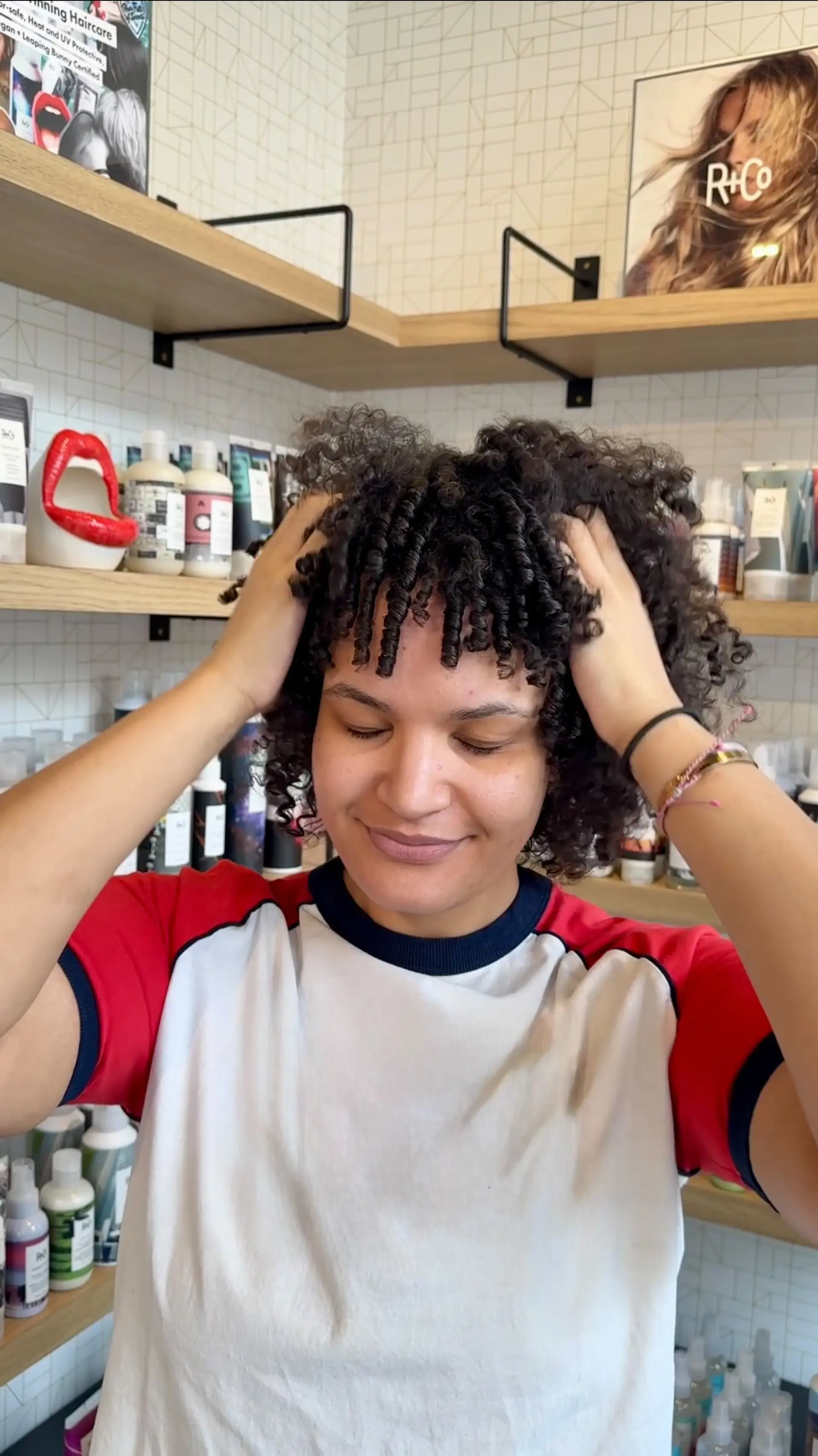A short, layered haircut shaped for natural curls, featuring defined ringlet bangs and bouncy volume. 1
