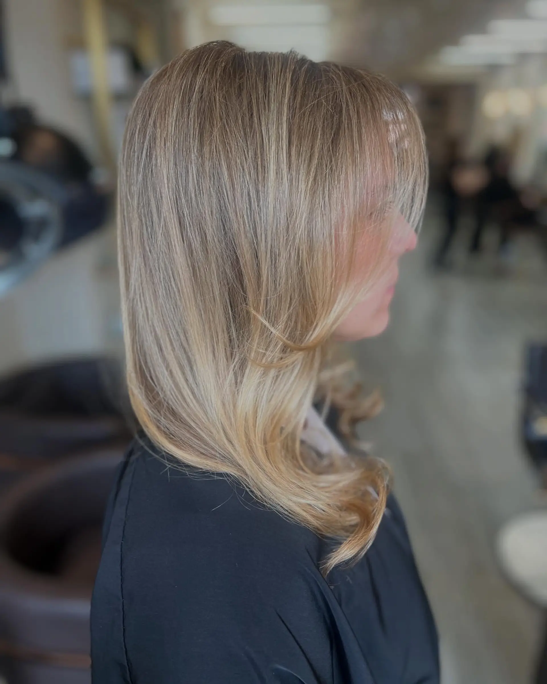 Medium-length warm golden blonde hair styled in a smooth blowout with soft face-framing layers. 1