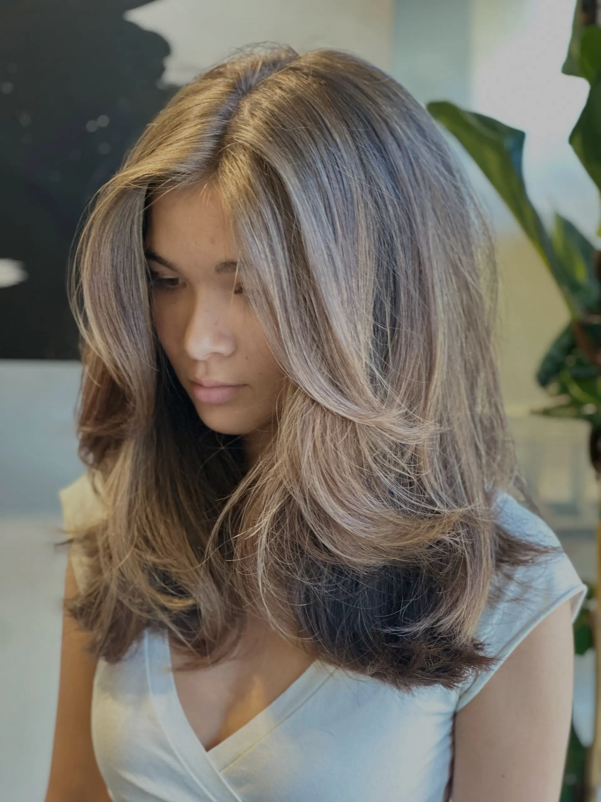 Long haircut featuring face-framing bouncy layers styled into a voluminous blowout with soft ash-toned highlights. 1