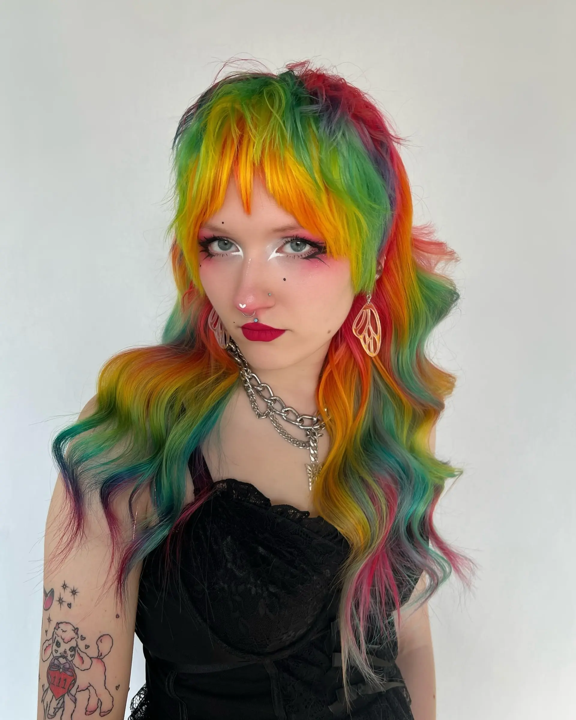 A multi-tonal rainbow shag haircut with choppy fringe and layered soft waves cascading past the shoulders. 1